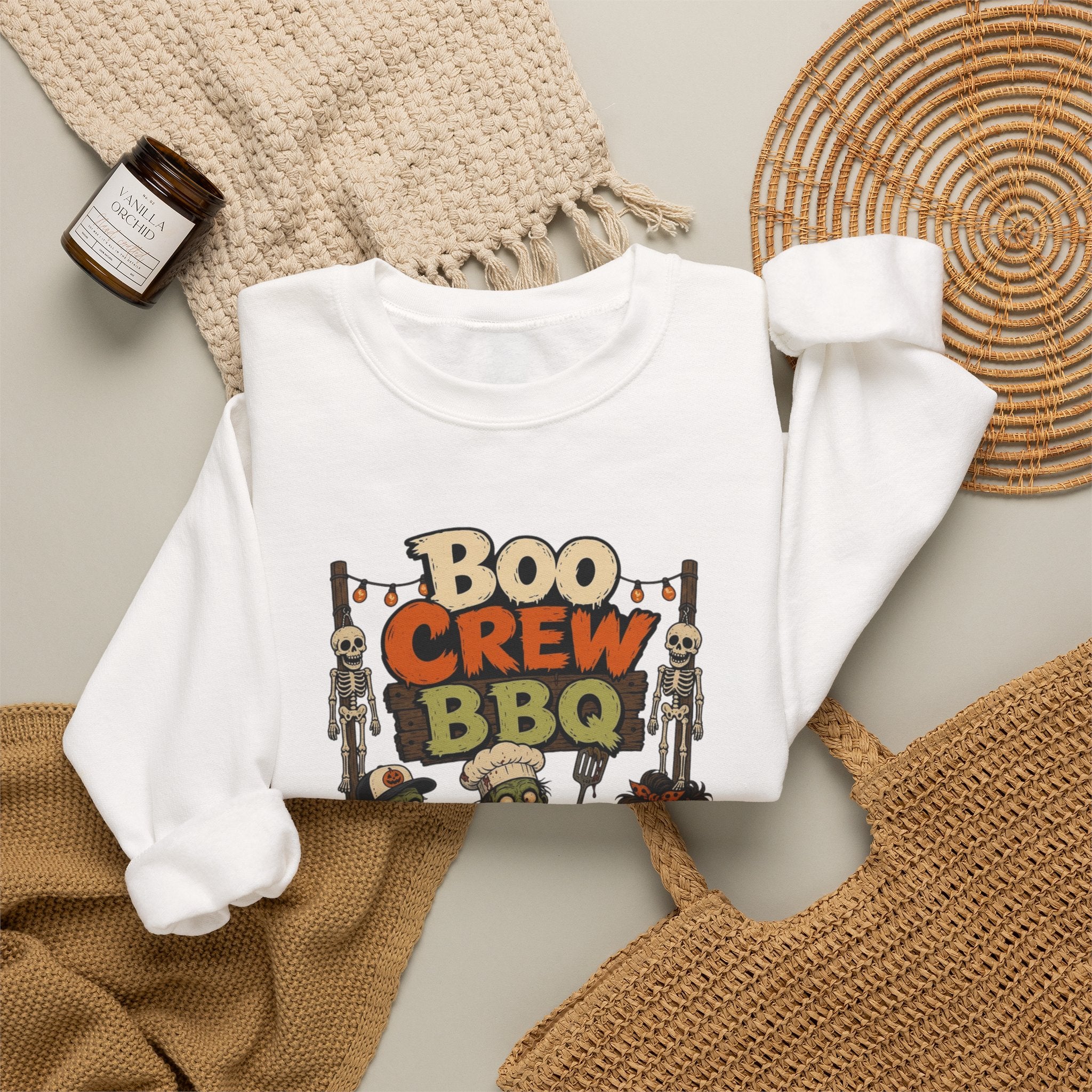 White crewneck sweatshirt styled flat with a candle — skeletons and zombies at the grill