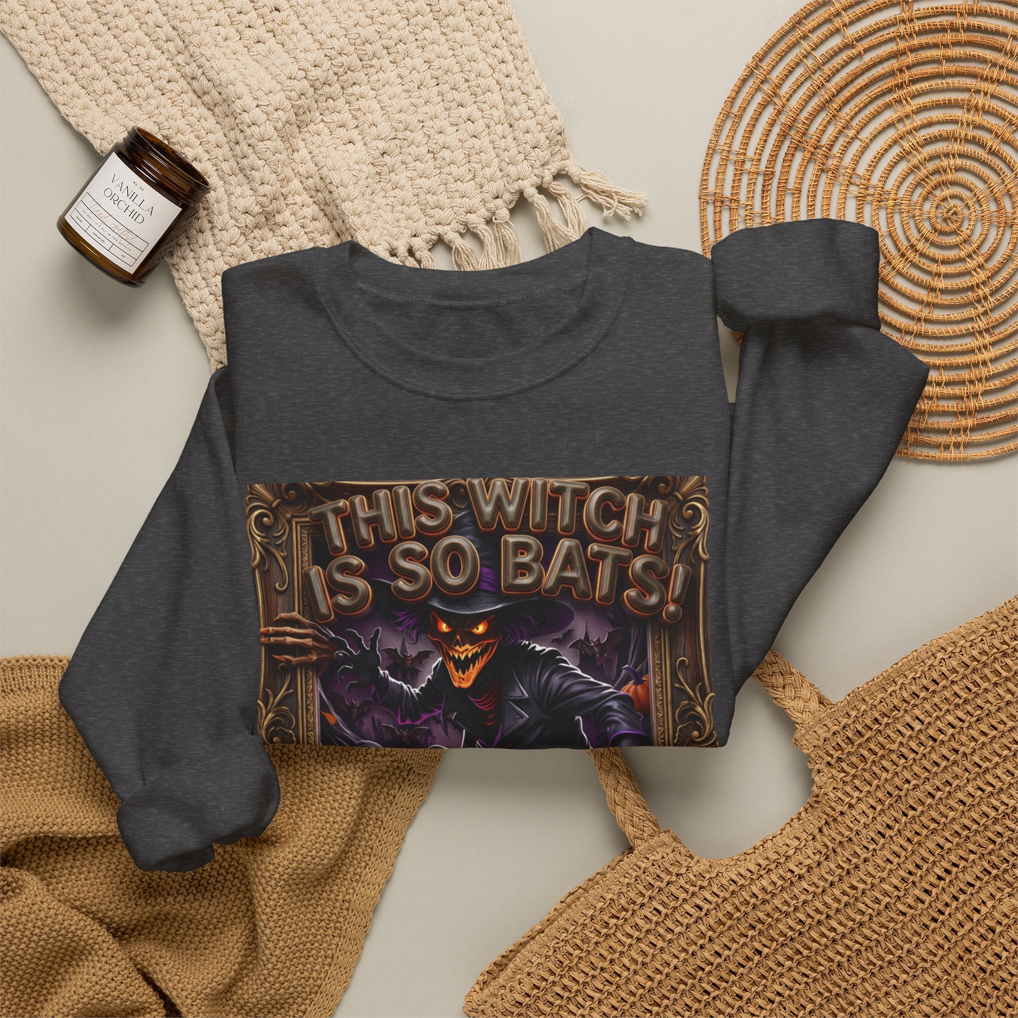 Dark Heather crewneck sweatshirt styled flat with a candle — grinning witch in a pointed hat