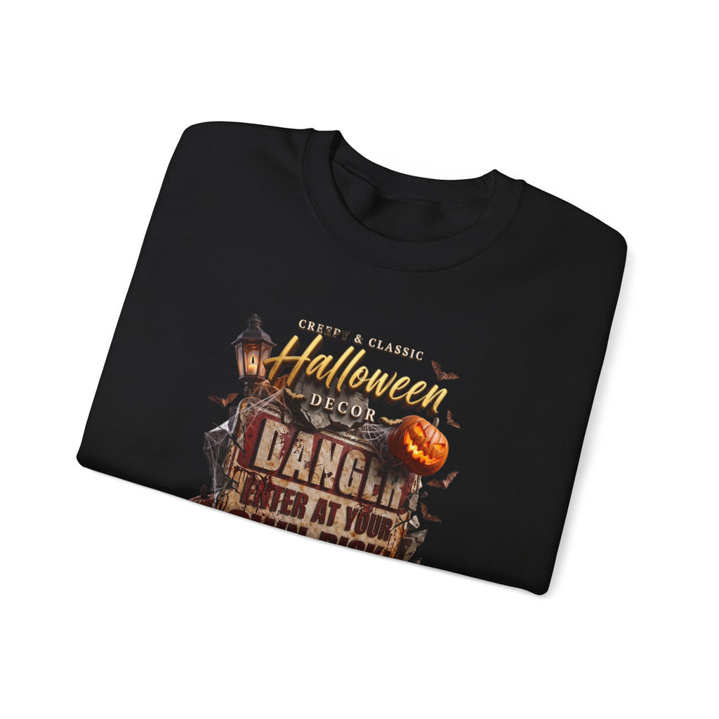 Black crewneck sweatshirt folded to show the aged danger sign hangs above a cluster of glowing print