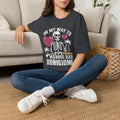 Dark Heather Grey t-shirt laid flat, printed with a two line drawn skeletons under pink hearts and bold