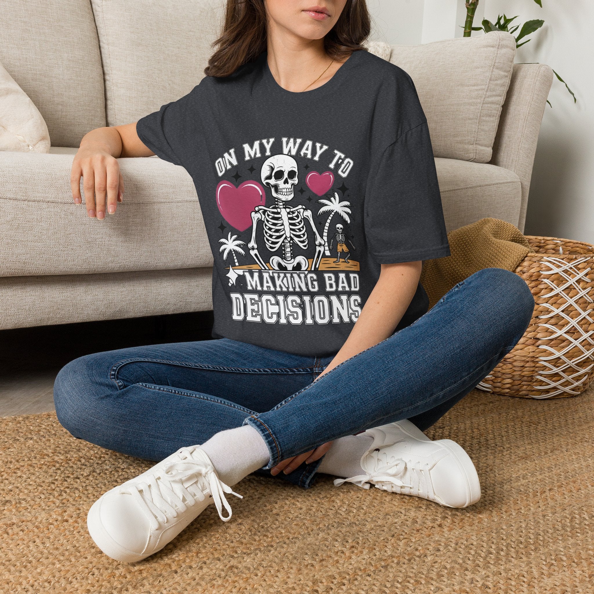 Dark Heather Grey t-shirt laid flat, printed with a two line drawn skeletons under pink hearts and bold