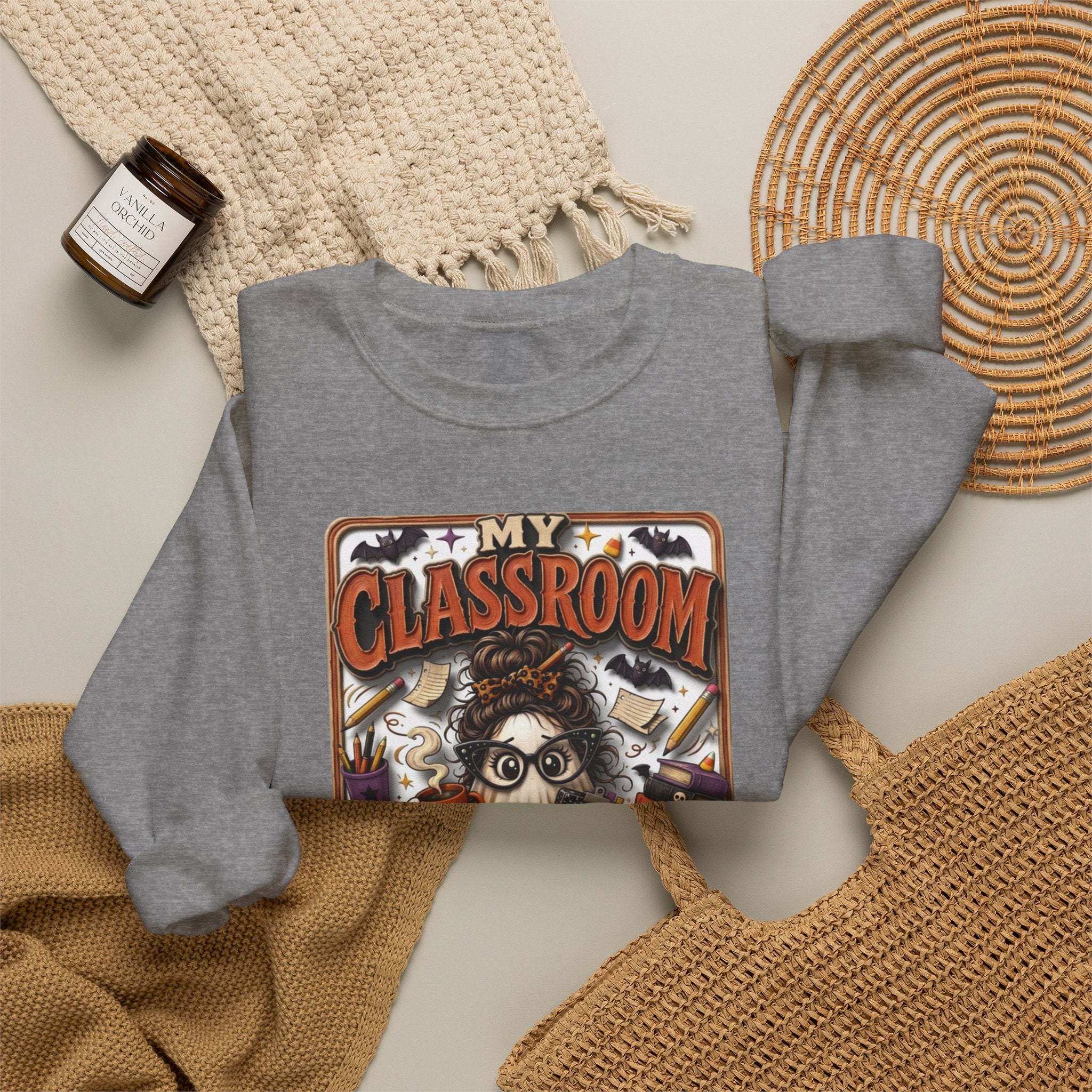 Graphite Heather crewneck sweatshirt styled flat with a candle — bespectacled ghost grading papers