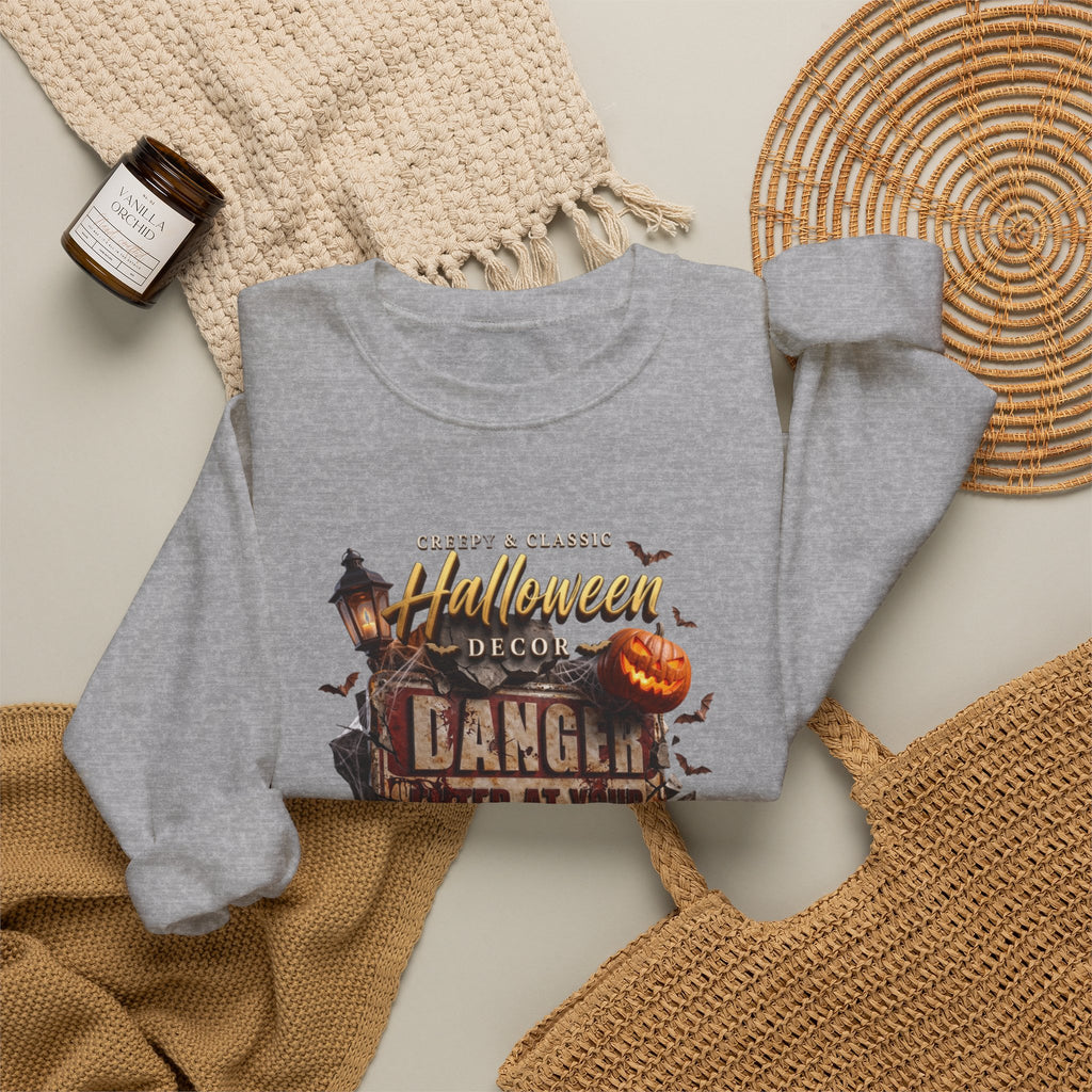 Sport Grey crewneck sweatshirt styled flat with a candle — aged Danger sign over glowing pumpkins