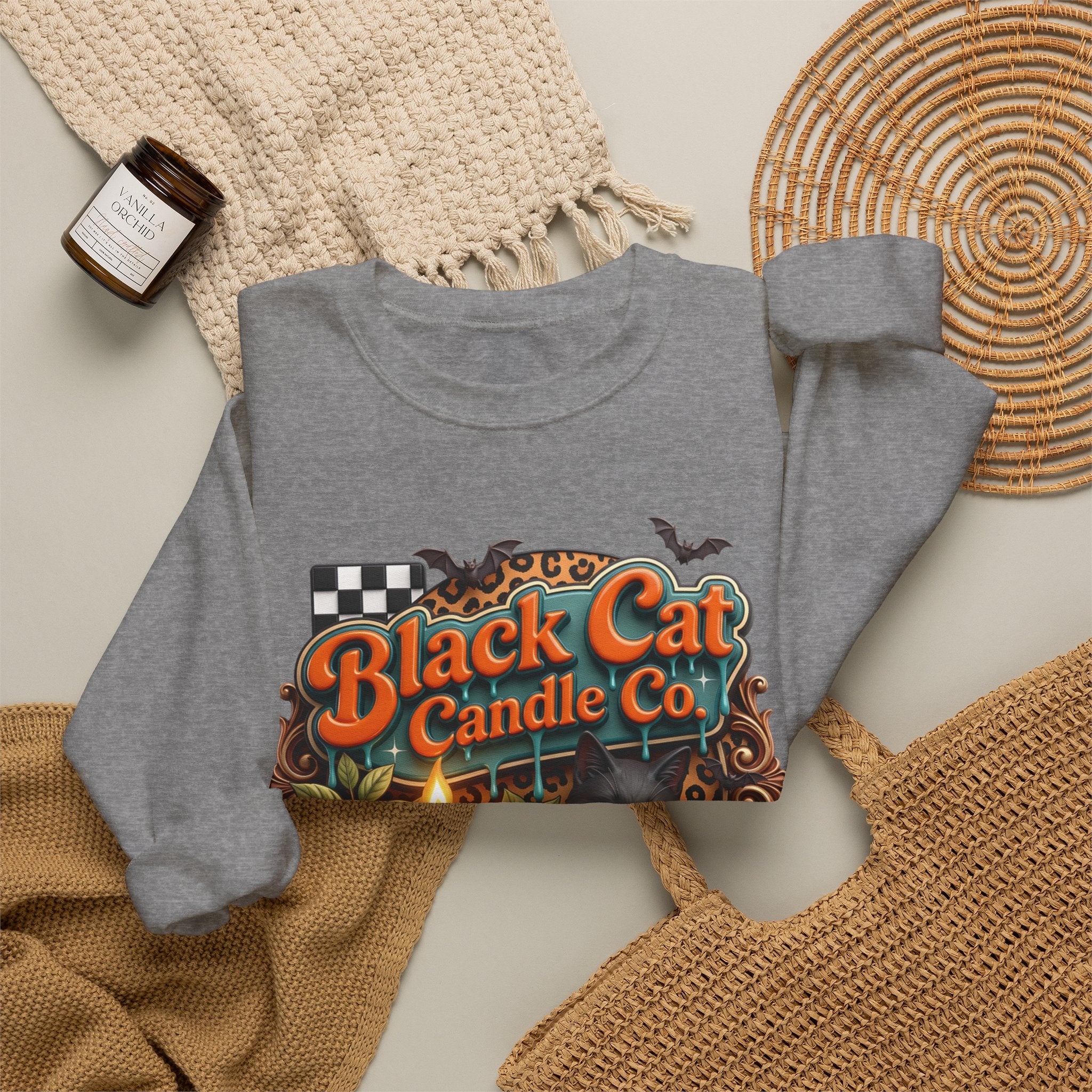 Graphite Heather crewneck sweatshirt styled flat with a candle — retro Black Cat Candle Co signboard