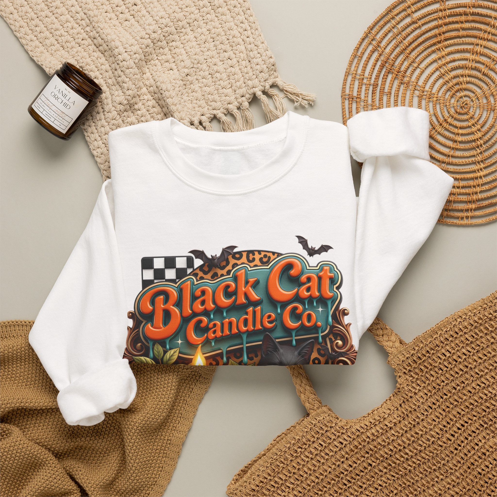 White crewneck sweatshirt styled flat with a candle — retro Black Cat Candle Co signboard