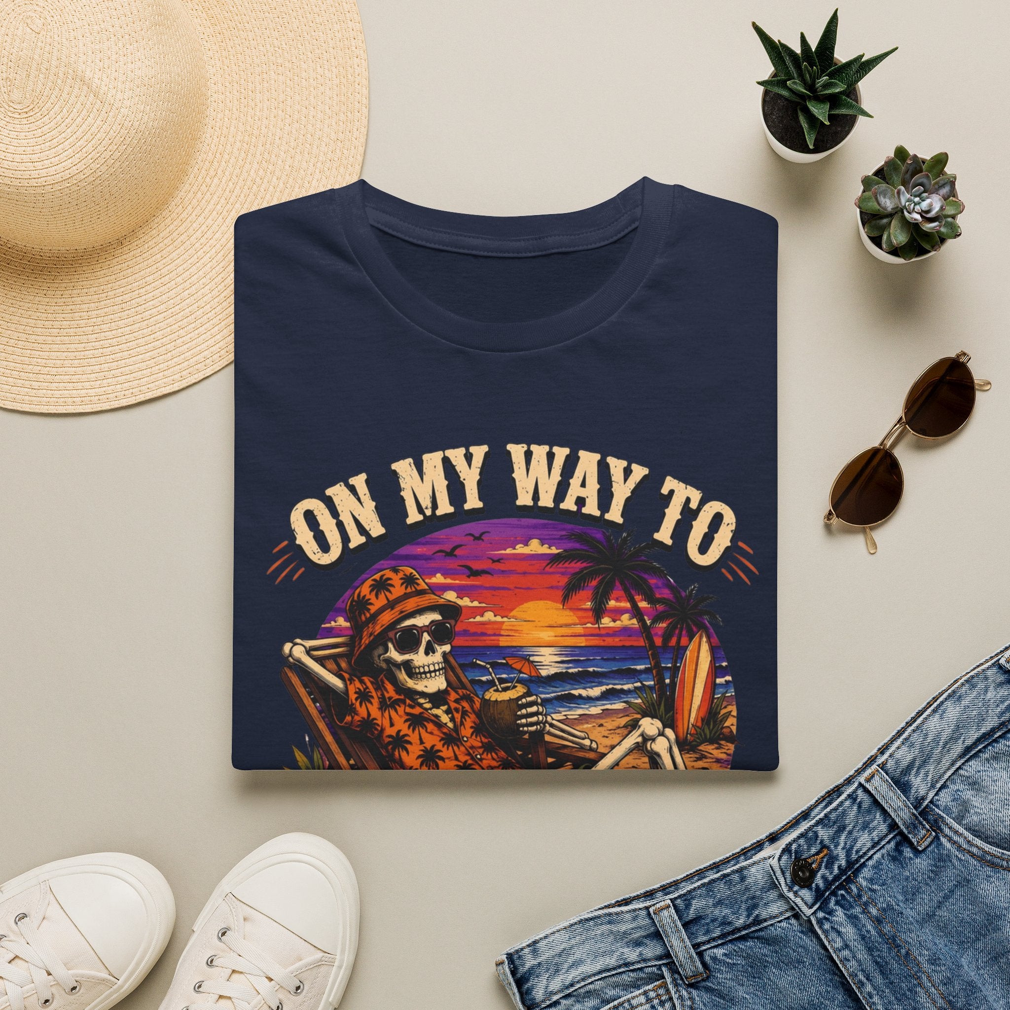 Navy t-shirt styled flat with a candle — skeleton on a beach at sunset