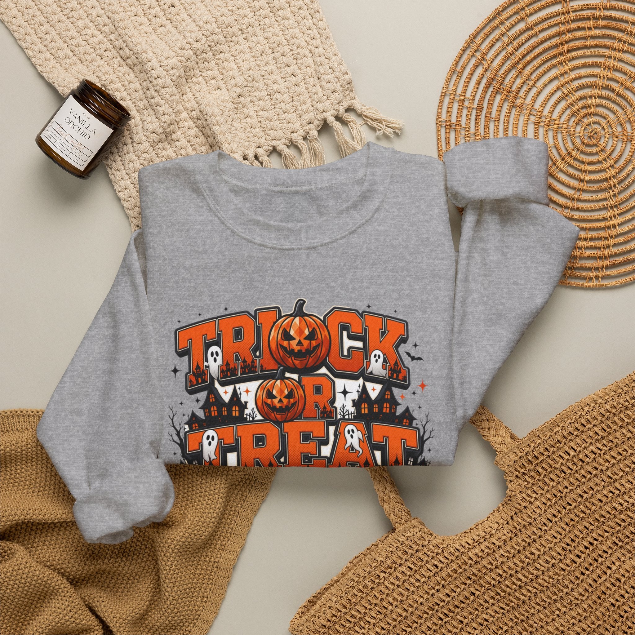 Sport Grey crewneck sweatshirt styled flat with a candle — stacked orange and black lettering