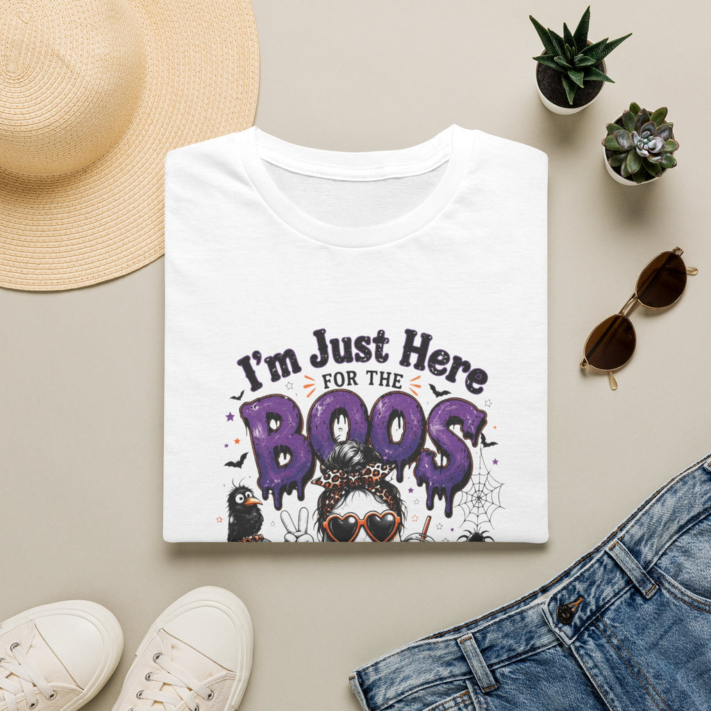 White t-shirt styled flat with a candle — cartoon ghosts in sunglasses over pumpkins