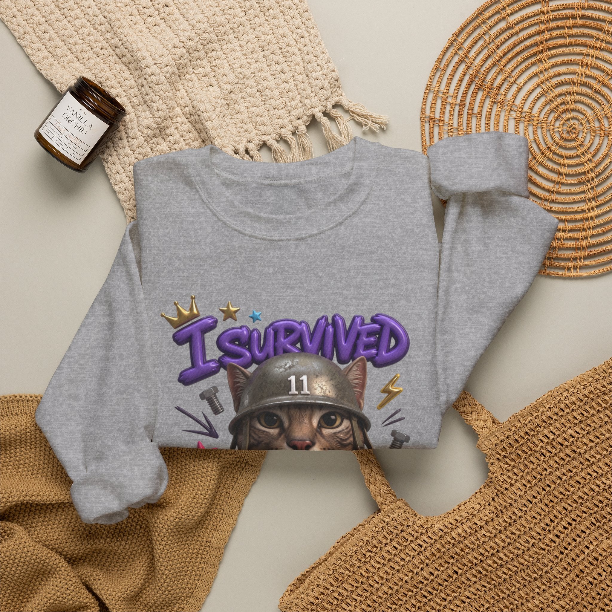 Sport Grey crewneck sweatshirt styled flat with a candle — flat-eyed cat in a steel helmet