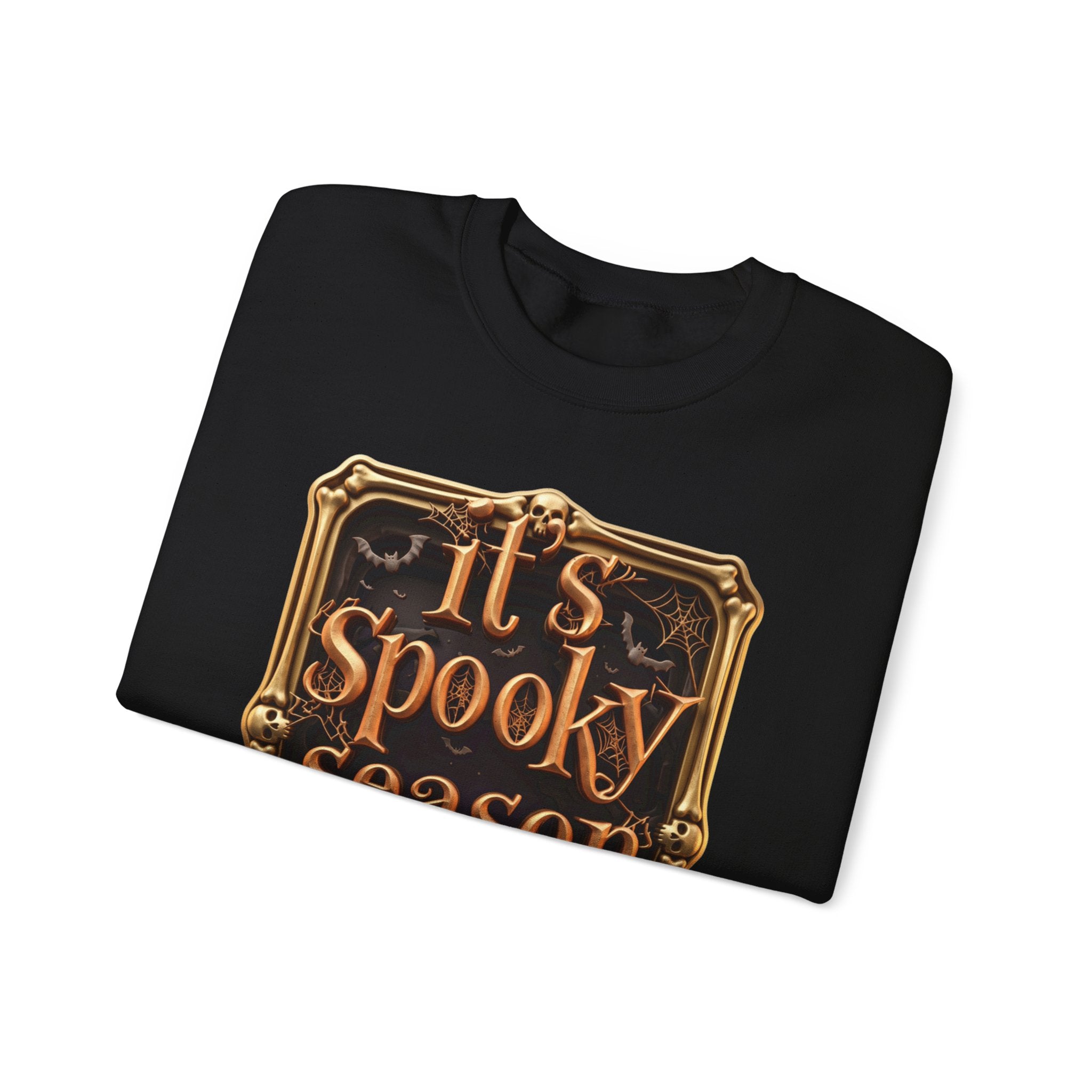 Black crewneck sweatshirt folded to show the copper serif lettering reads it's spooky season inside print