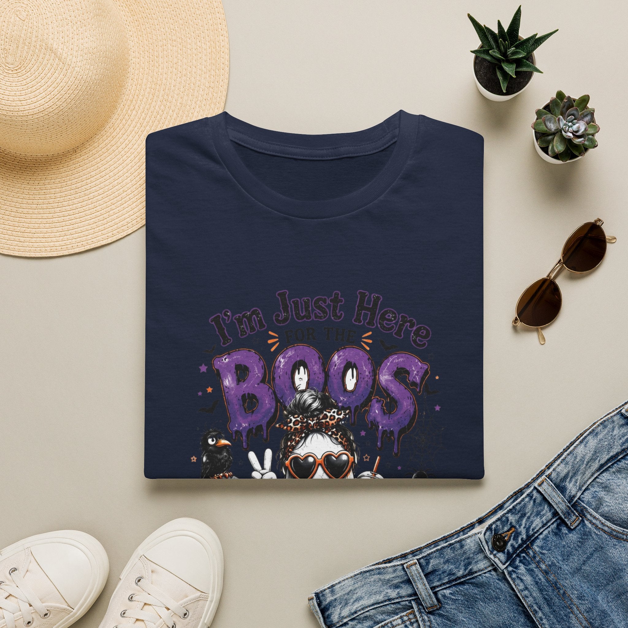 Navy t-shirt styled flat with a candle — cartoon ghosts in sunglasses over pumpkins