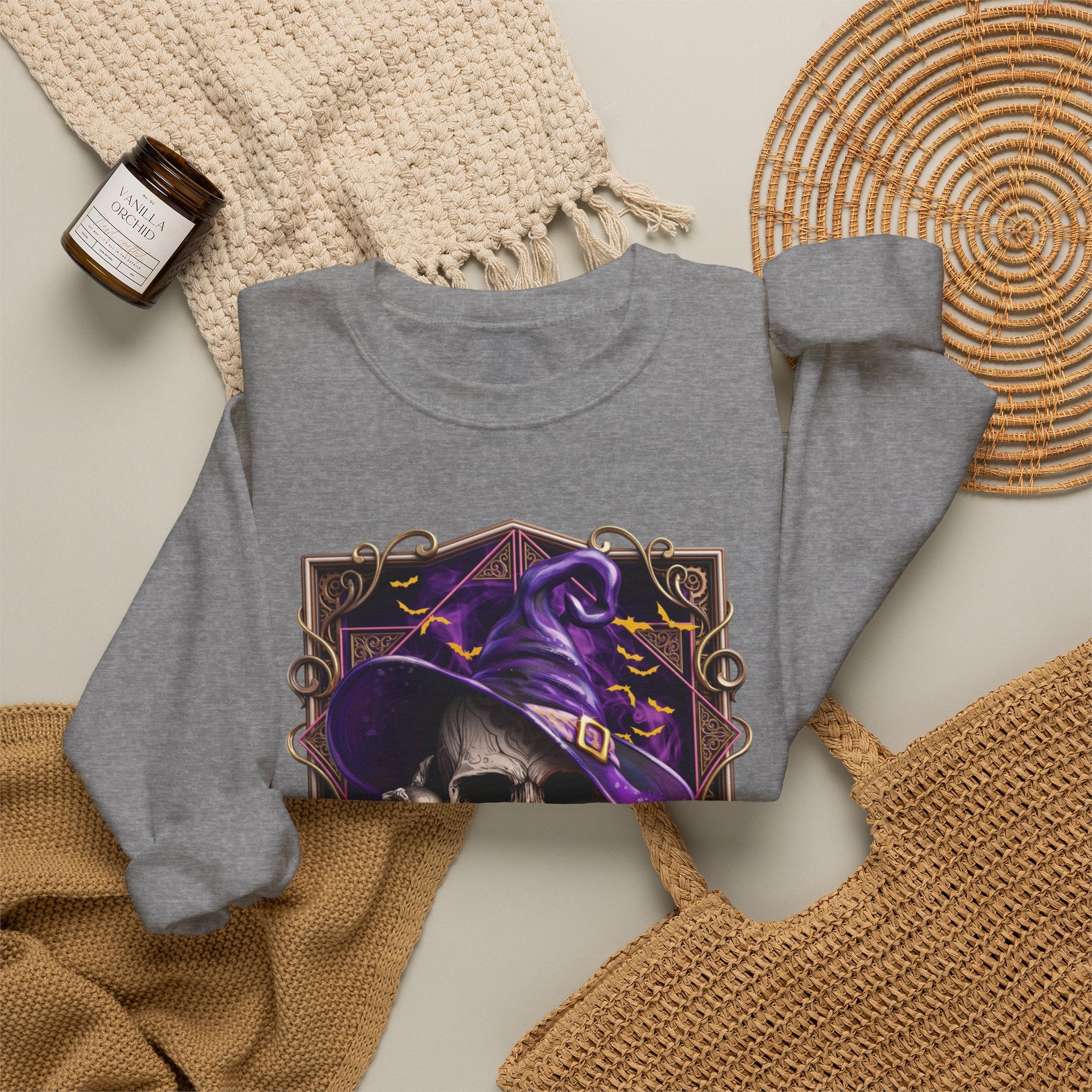 Graphite Heather crewneck sweatshirt styled flat with a candle — skull in a purple witch hat