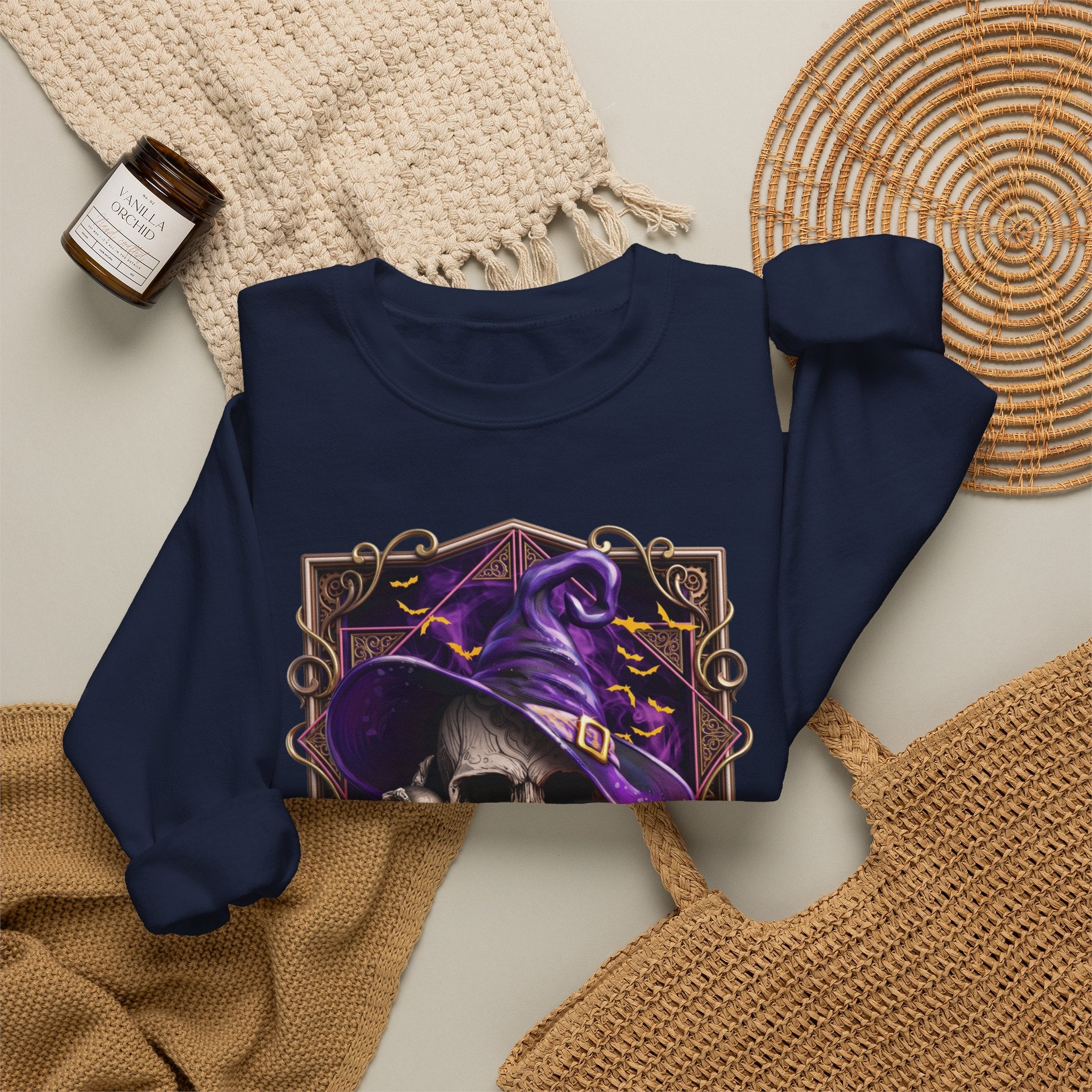 Navy crewneck sweatshirt styled flat with a candle — skull in a purple witch hat