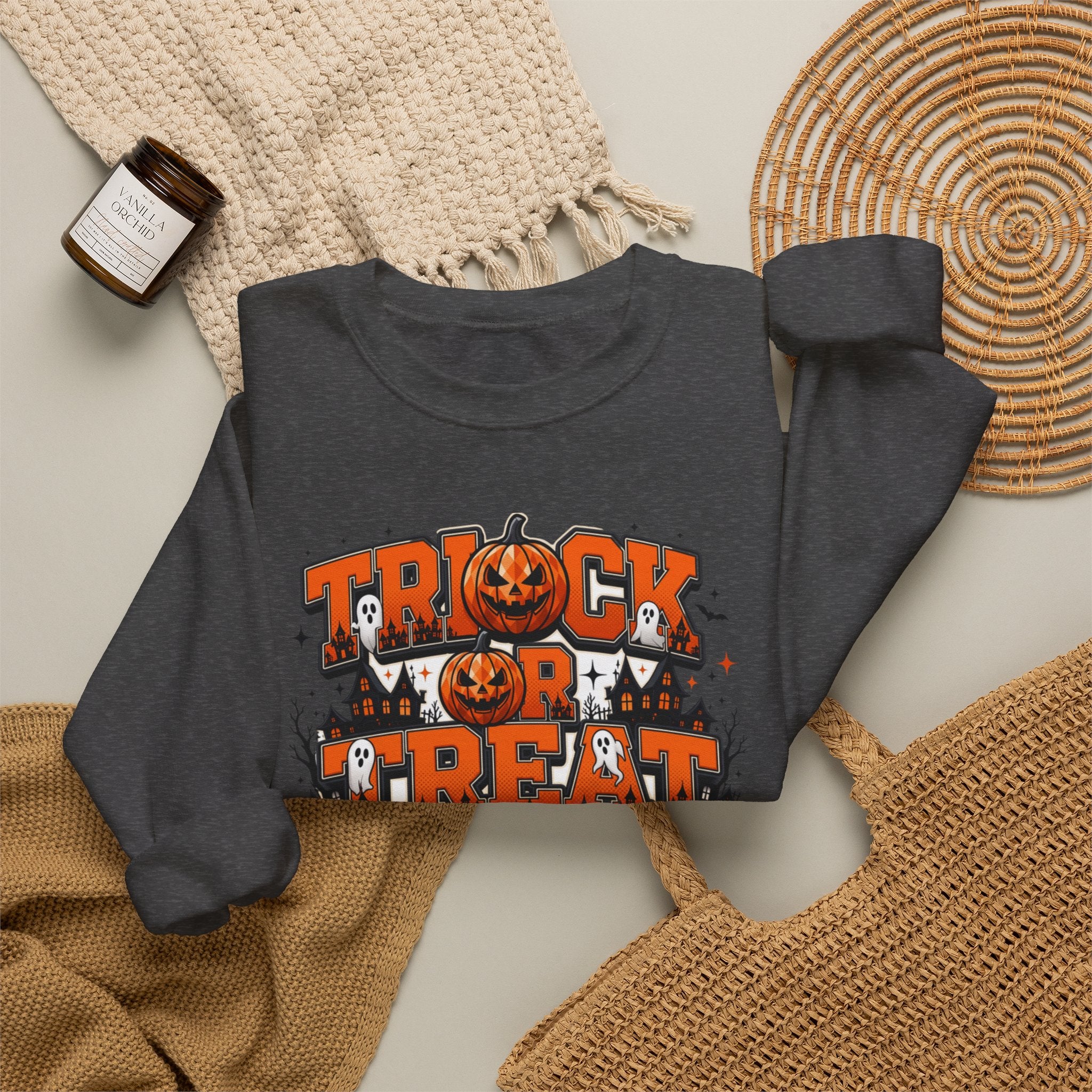 Dark Heather crewneck sweatshirt styled flat with a candle — stacked orange and black lettering
