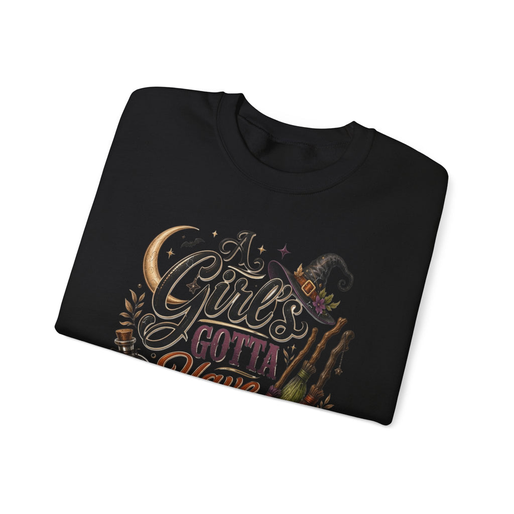 Black crewneck sweatshirt folded to show the hand-lettered script reading a girl's gotta have options print