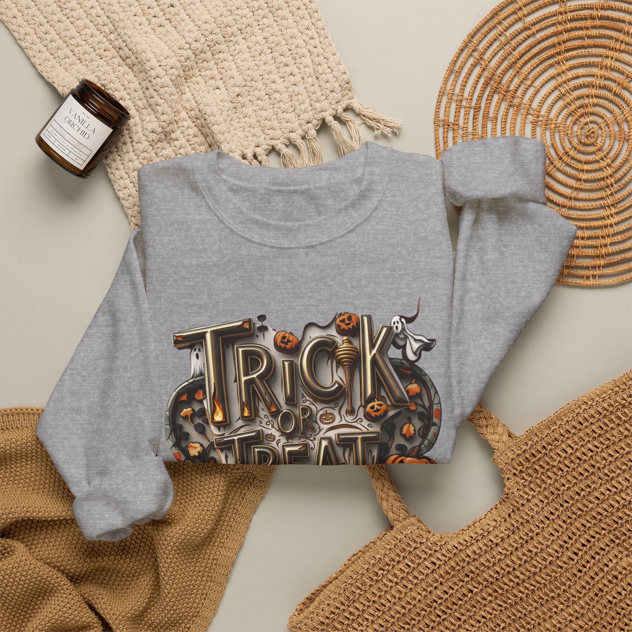 Sport Grey crewneck sweatshirt styled flat with a candle — carved Trick or Treat Yourself lettering