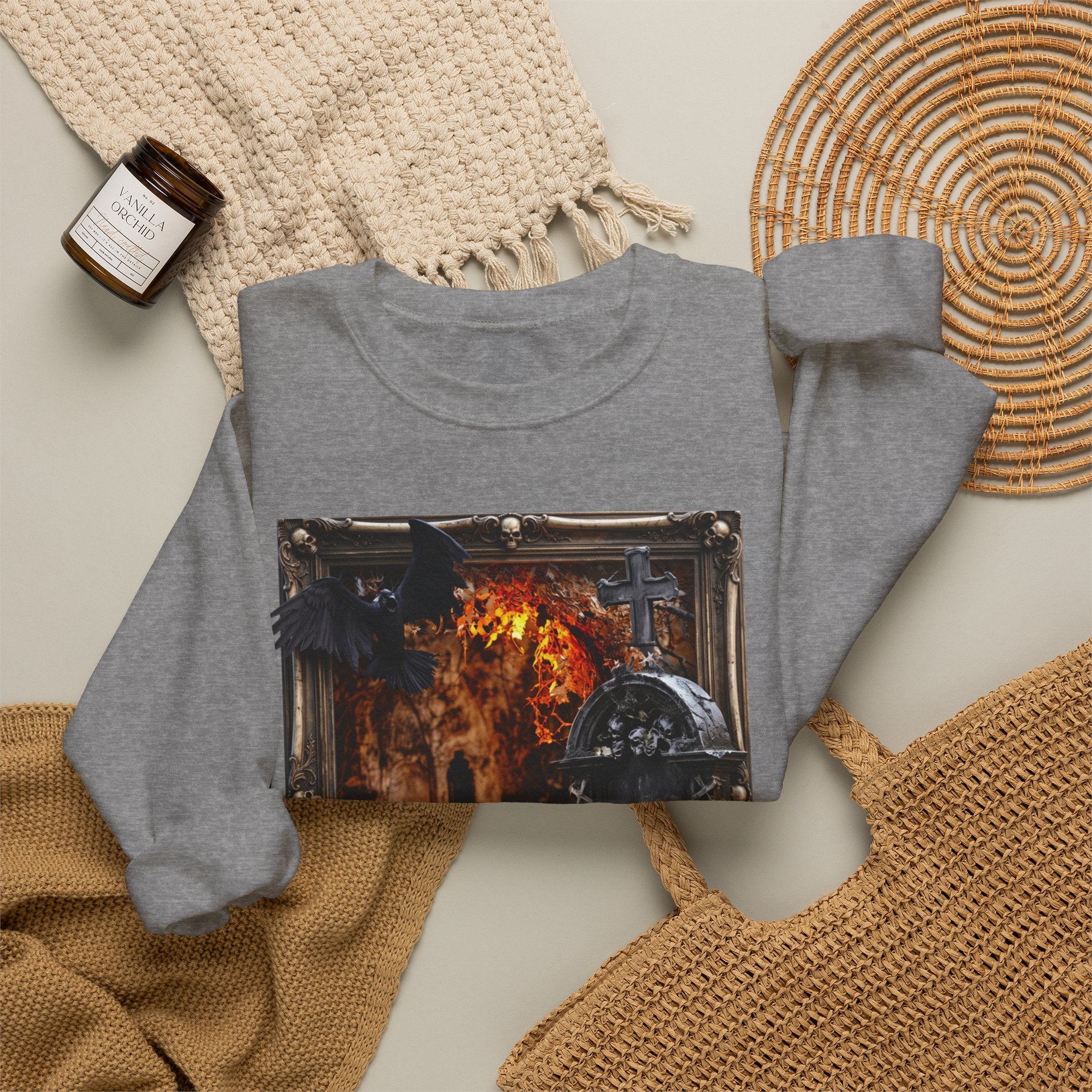 Graphite Heather crewneck sweatshirt styled flat with a candle — framed stone tomb scene