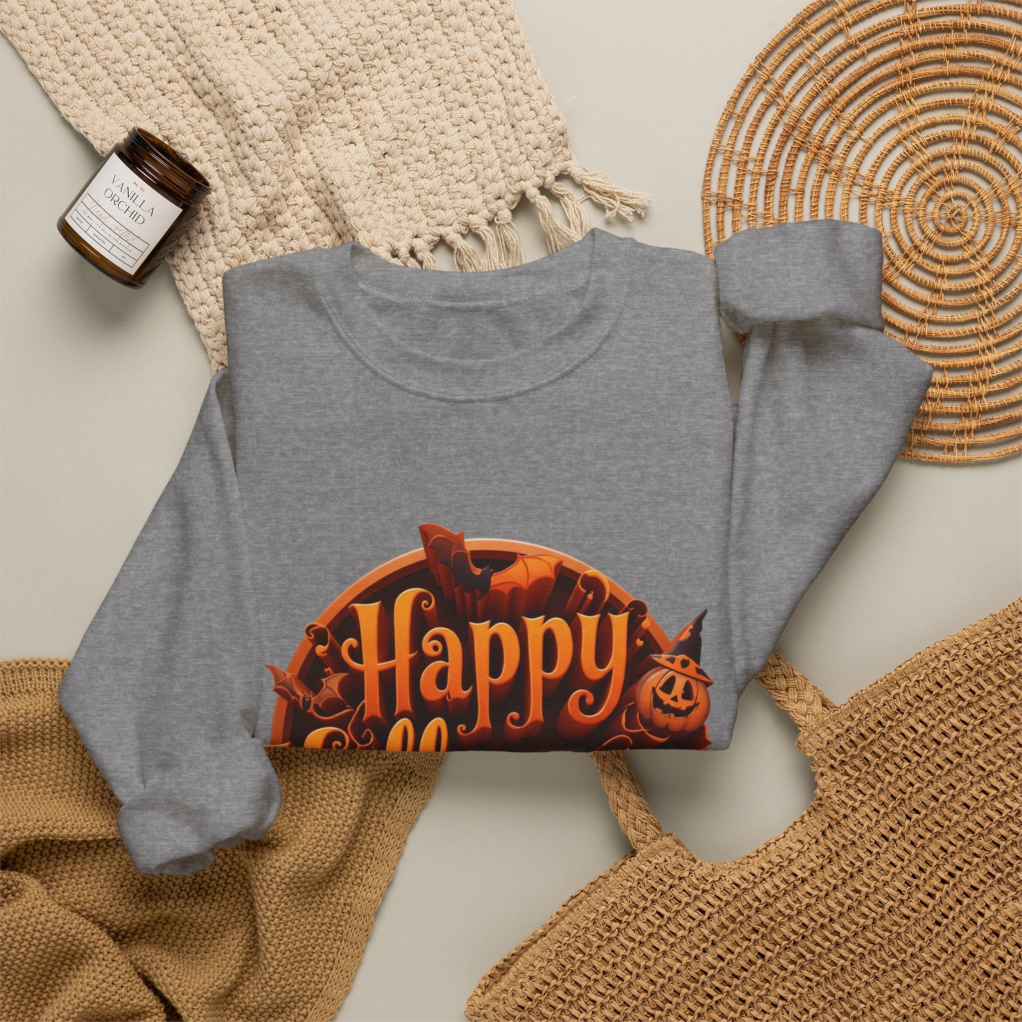 Graphite Heather crewneck sweatshirt styled flat with a candle — glowing orange Happy Halloween badge