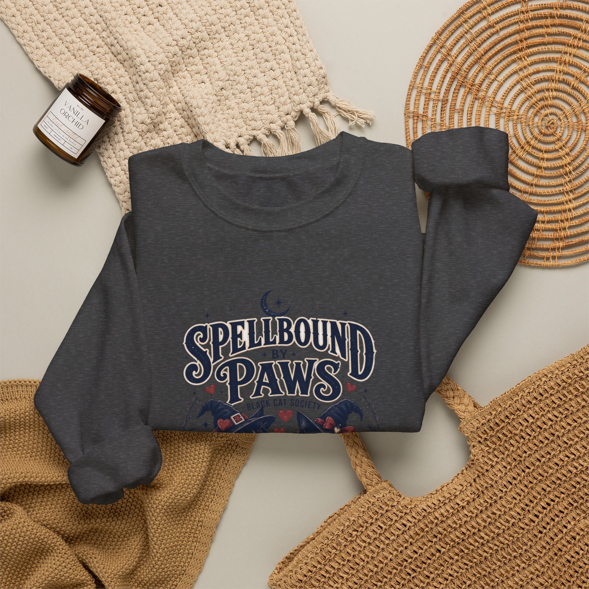 Dark Heather crewneck sweatshirt styled flat with a candle — two black cats in witch hats