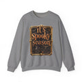 Graphite Heather crewneck sweatshirt laid flat, printed with a copper serif lettering reads it's spooky season inside