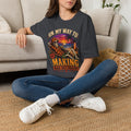 Dark Heather Grey t-shirt laid flat, printed with a skeleton lounging on a beach beneath a tropical sunset
