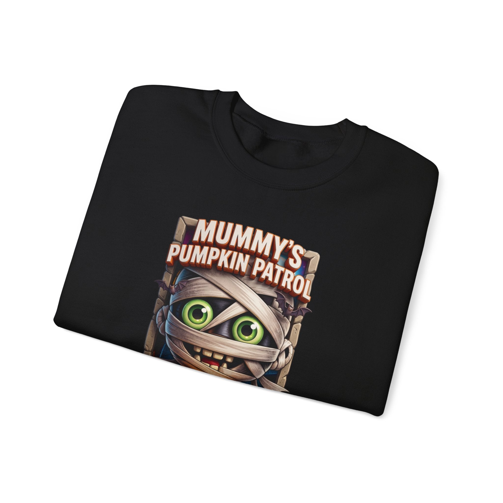 Black crewneck sweatshirt folded to show the wide-eyed cartoon mummy wrapped in bandages hugs a carved print