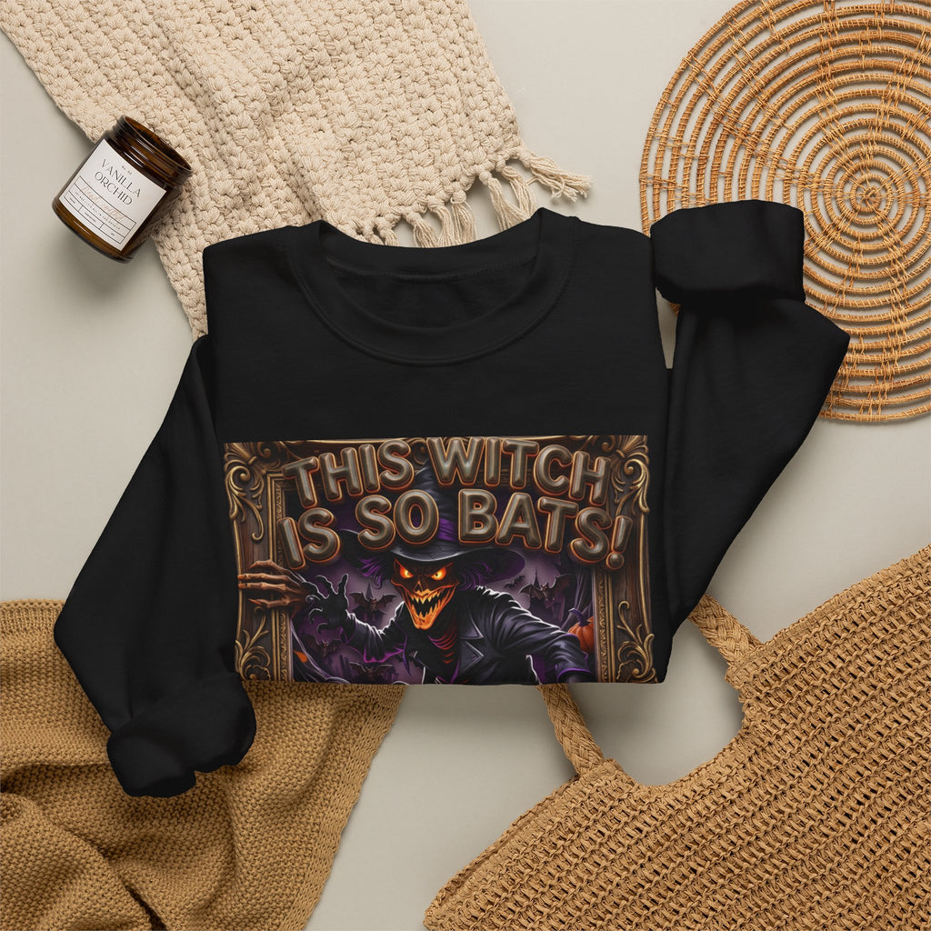 Black crewneck sweatshirt styled flat with a candle — grinning witch in a pointed hat