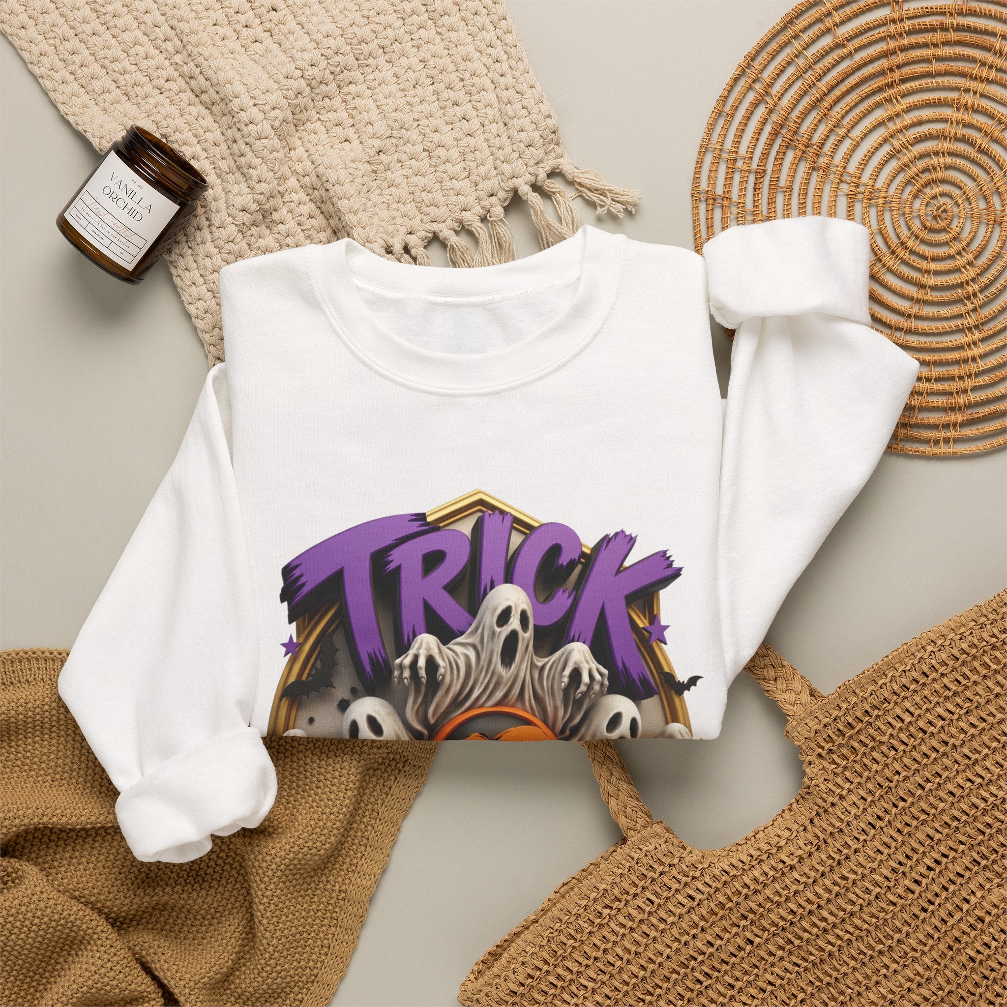 White crewneck sweatshirt styled flat with a candle — ghosts huddled between carved pumpkins