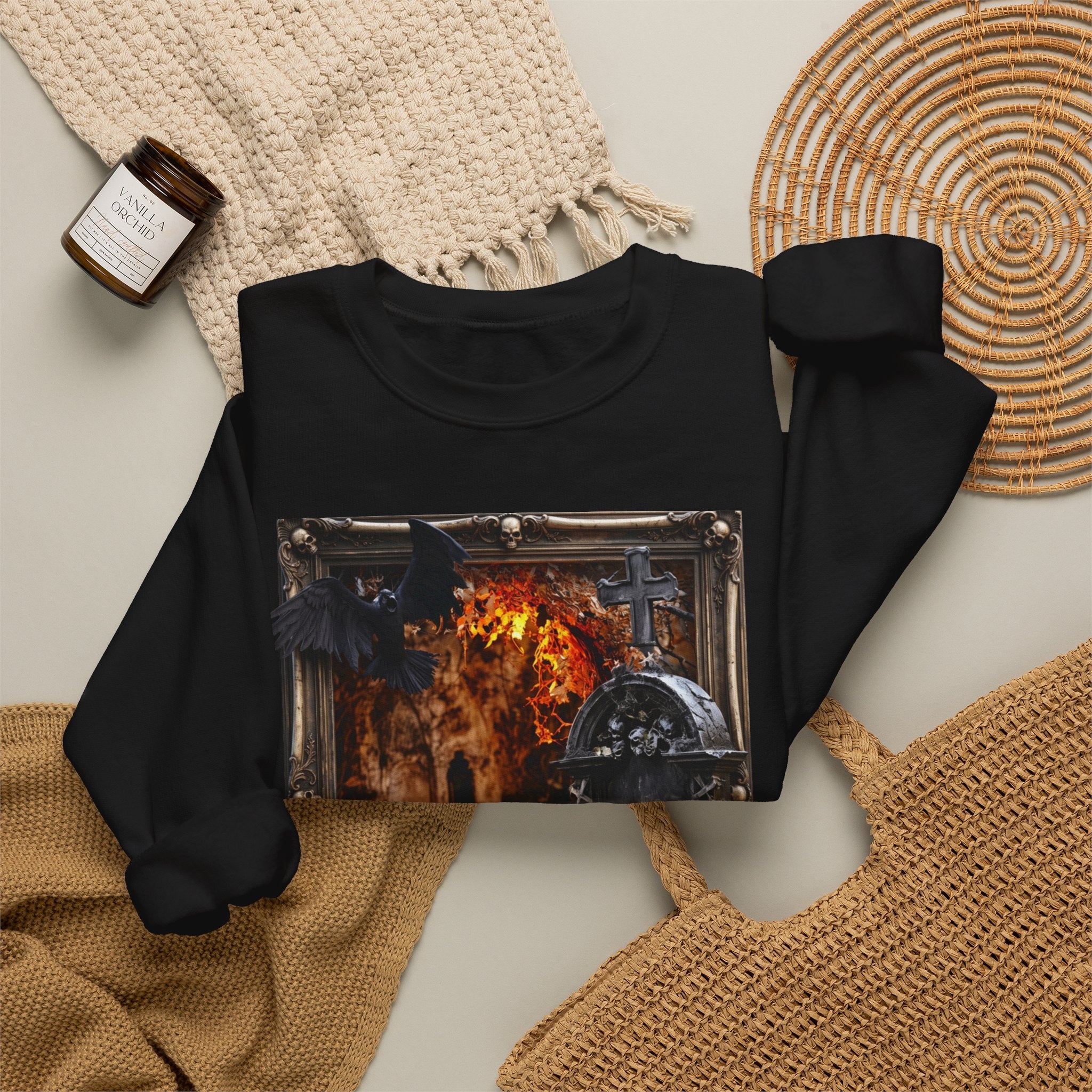 Black crewneck sweatshirt styled flat with a candle — framed stone tomb scene