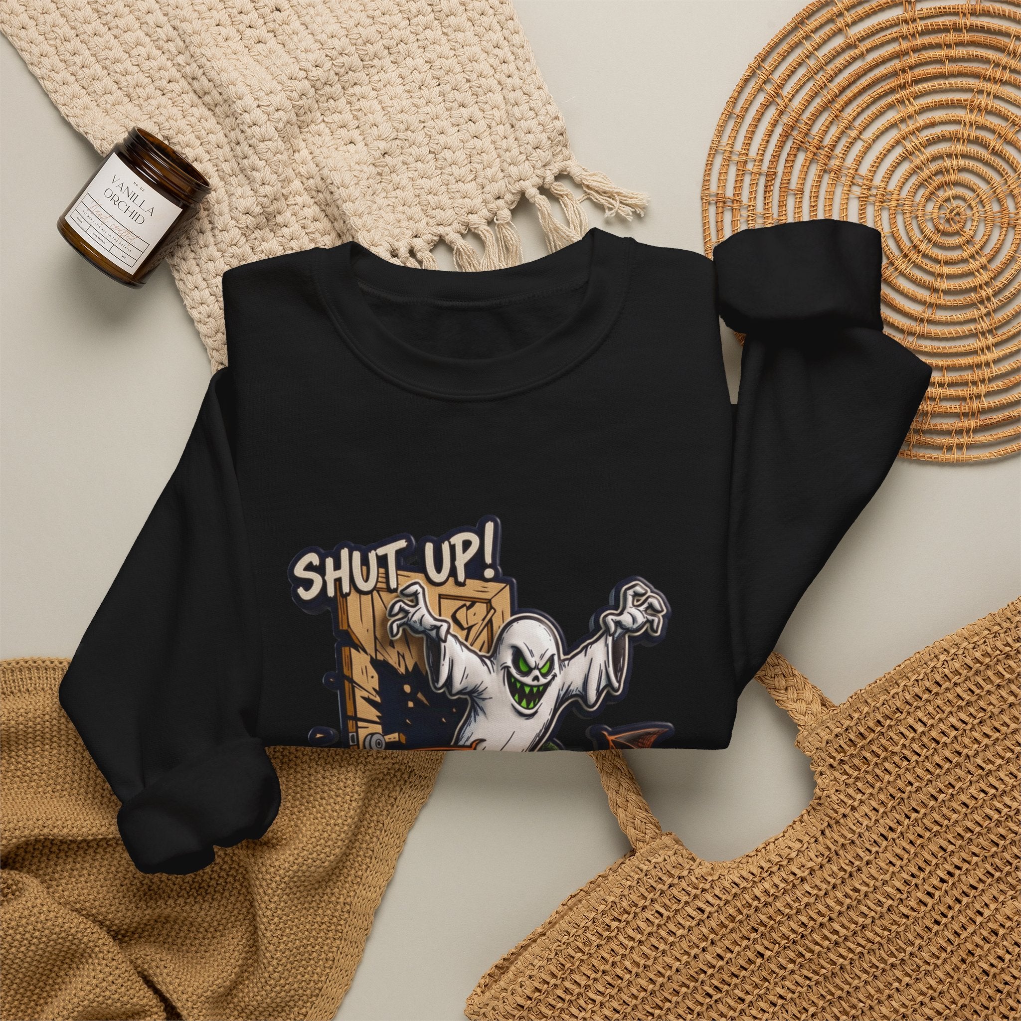 Black crewneck sweatshirt styled flat with a candle — green-eyed ghost with bat wings