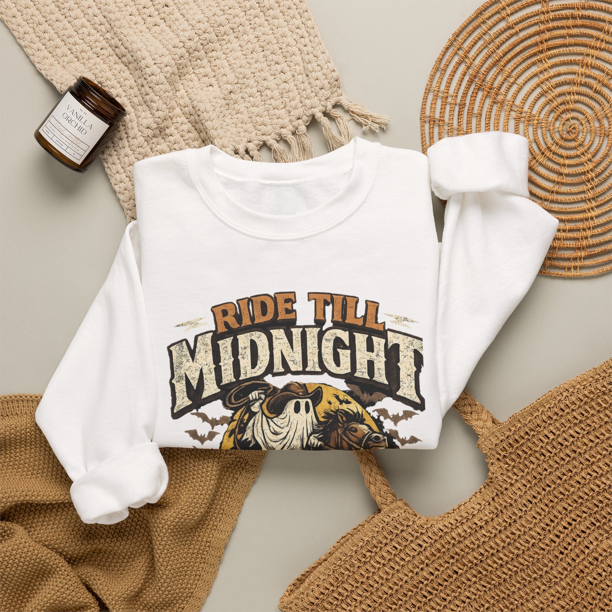 White crewneck sweatshirt styled flat with a candle — skeleton riding a motorcycle