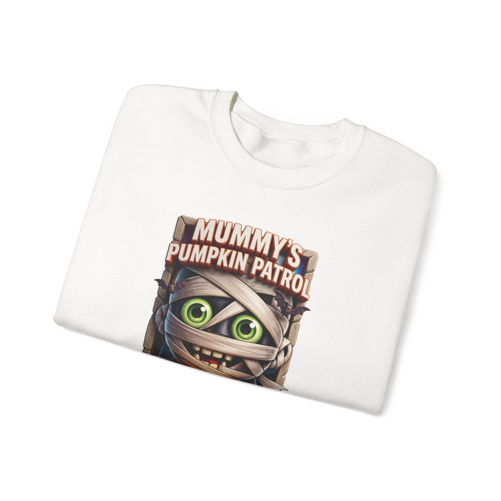 White crewneck sweatshirt folded to show the wide-eyed cartoon mummy wrapped in bandages hugs a carved print