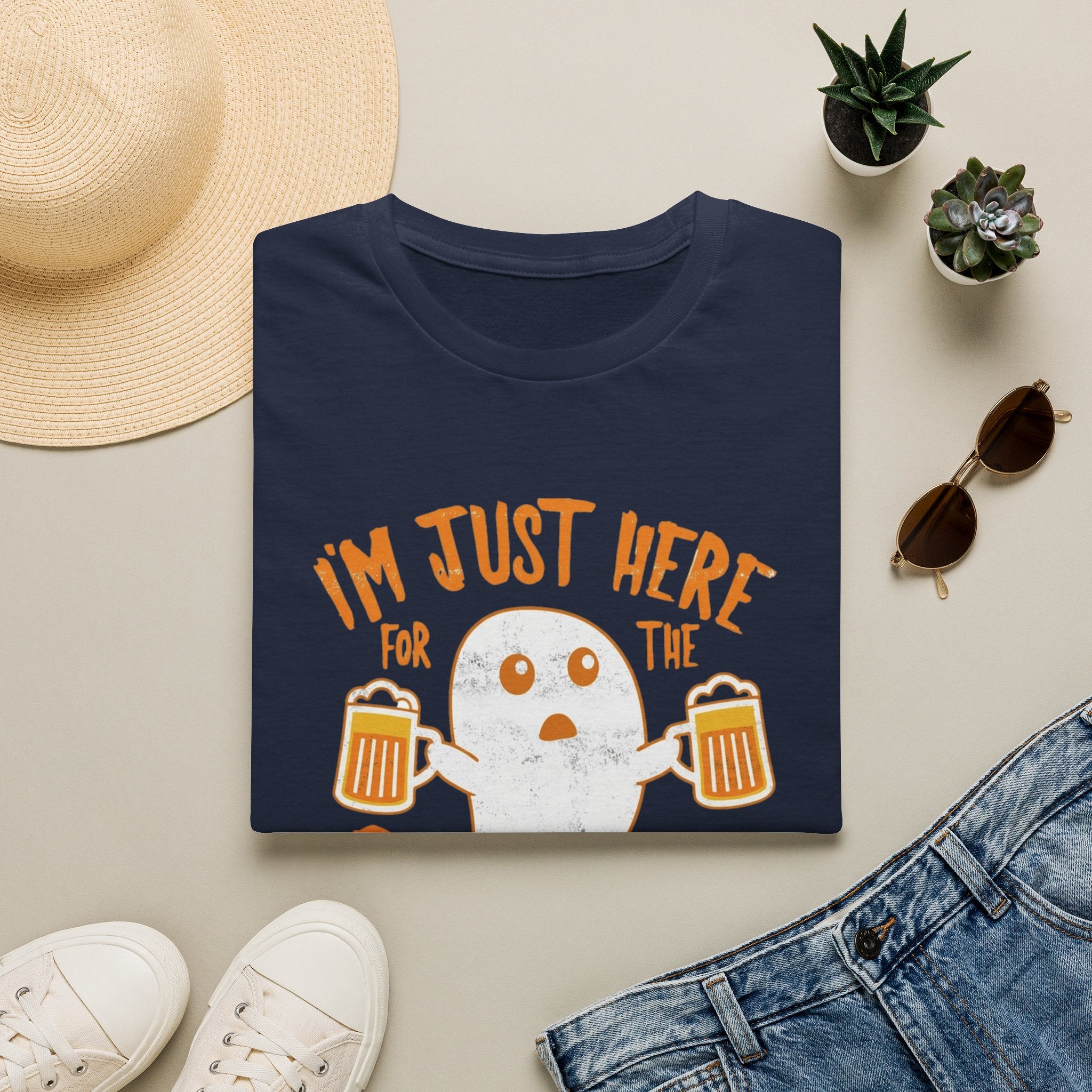 Navy t-shirt styled flat with a candle — wide-eyed ghost raising a frothy pint