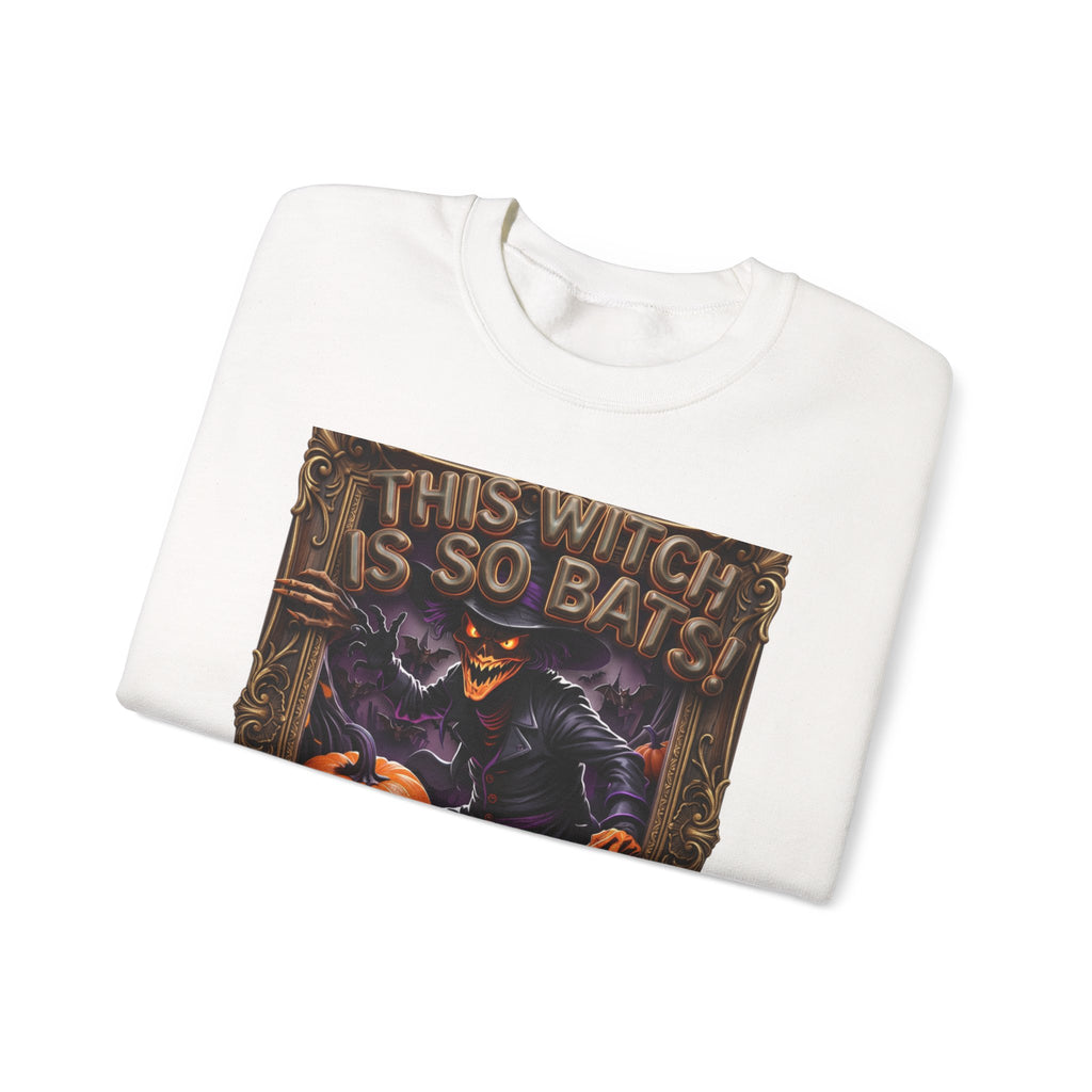White crewneck sweatshirt folded to show the grinning witch in a pointed hat looms over glowing print
