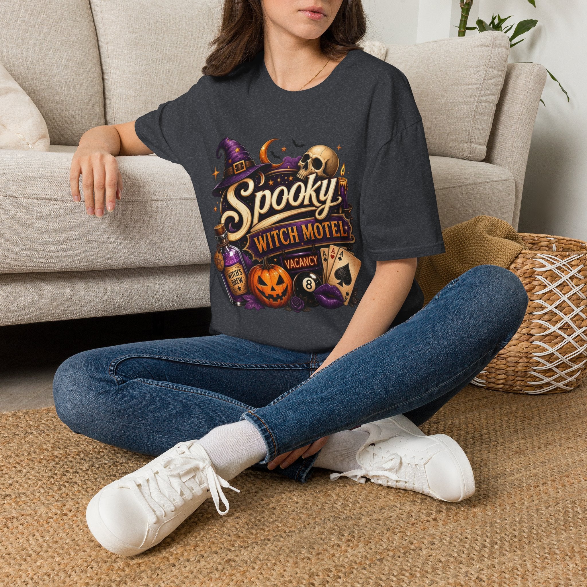 Dark Heather Grey t-shirt laid flat, printed with a neon motel sign reading spooky witch motel