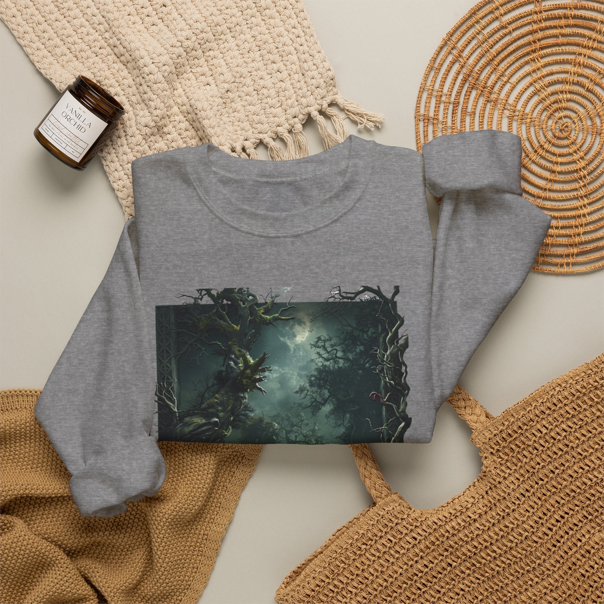 Graphite Heather crewneck sweatshirt styled flat with a candle — moonlit forest of gnarled mossy trees