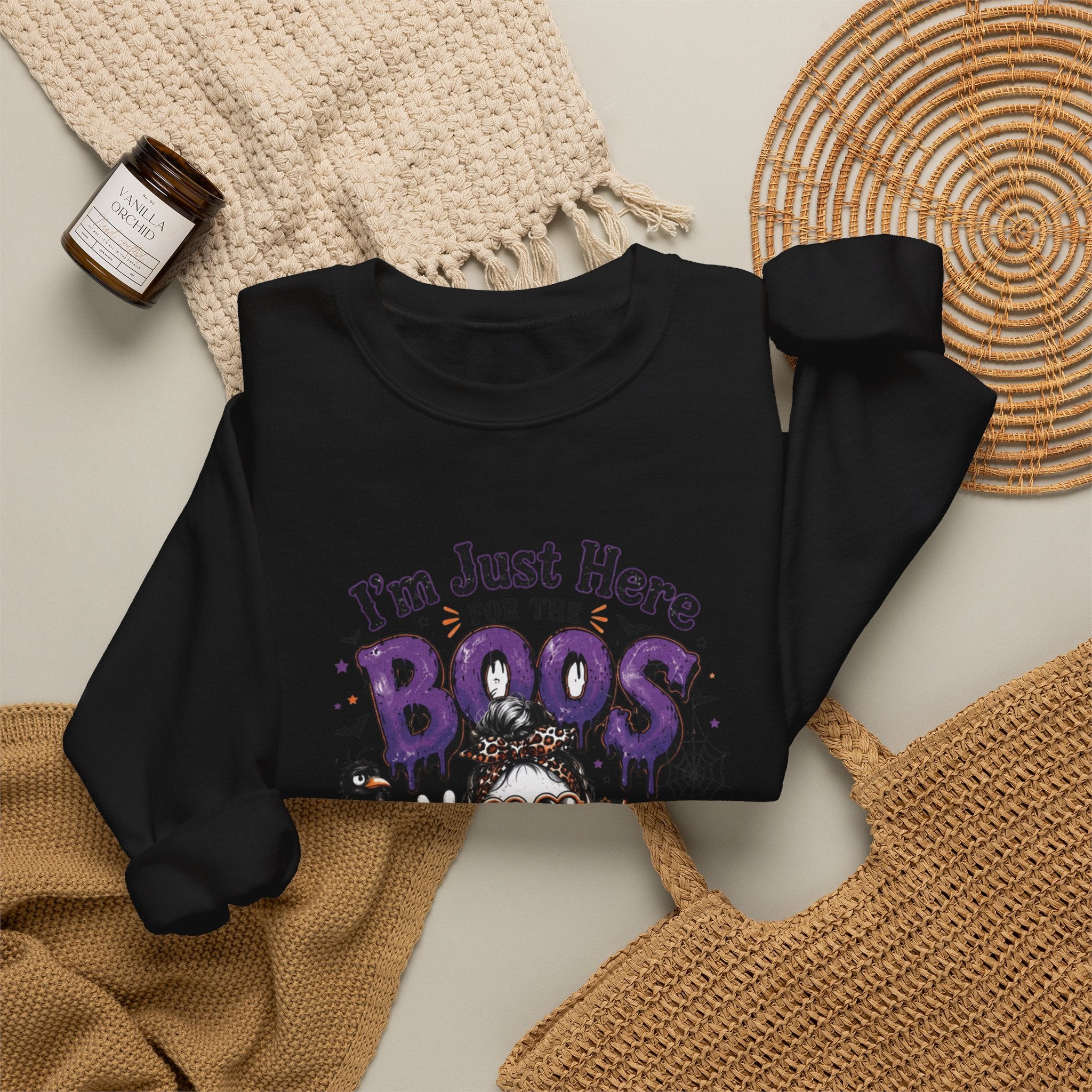 Black crewneck sweatshirt styled flat with a candle — three cartoon ghosts in sunglasses