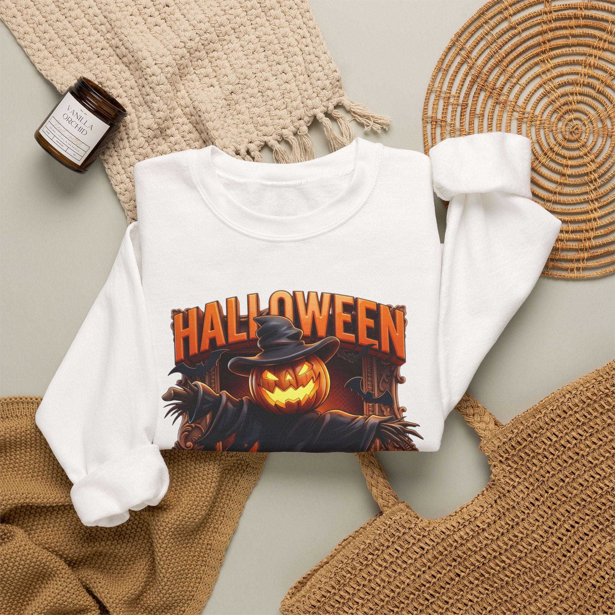 White crewneck sweatshirt styled flat with a candle — scarecrow with a jack-o-lantern head
