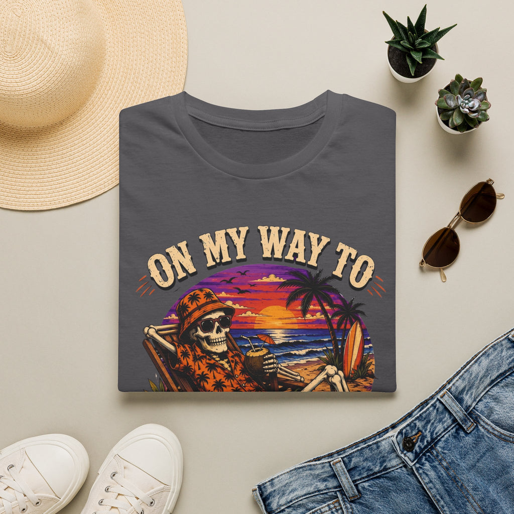 Charcoal t-shirt styled flat with a candle — skeleton on a beach at sunset