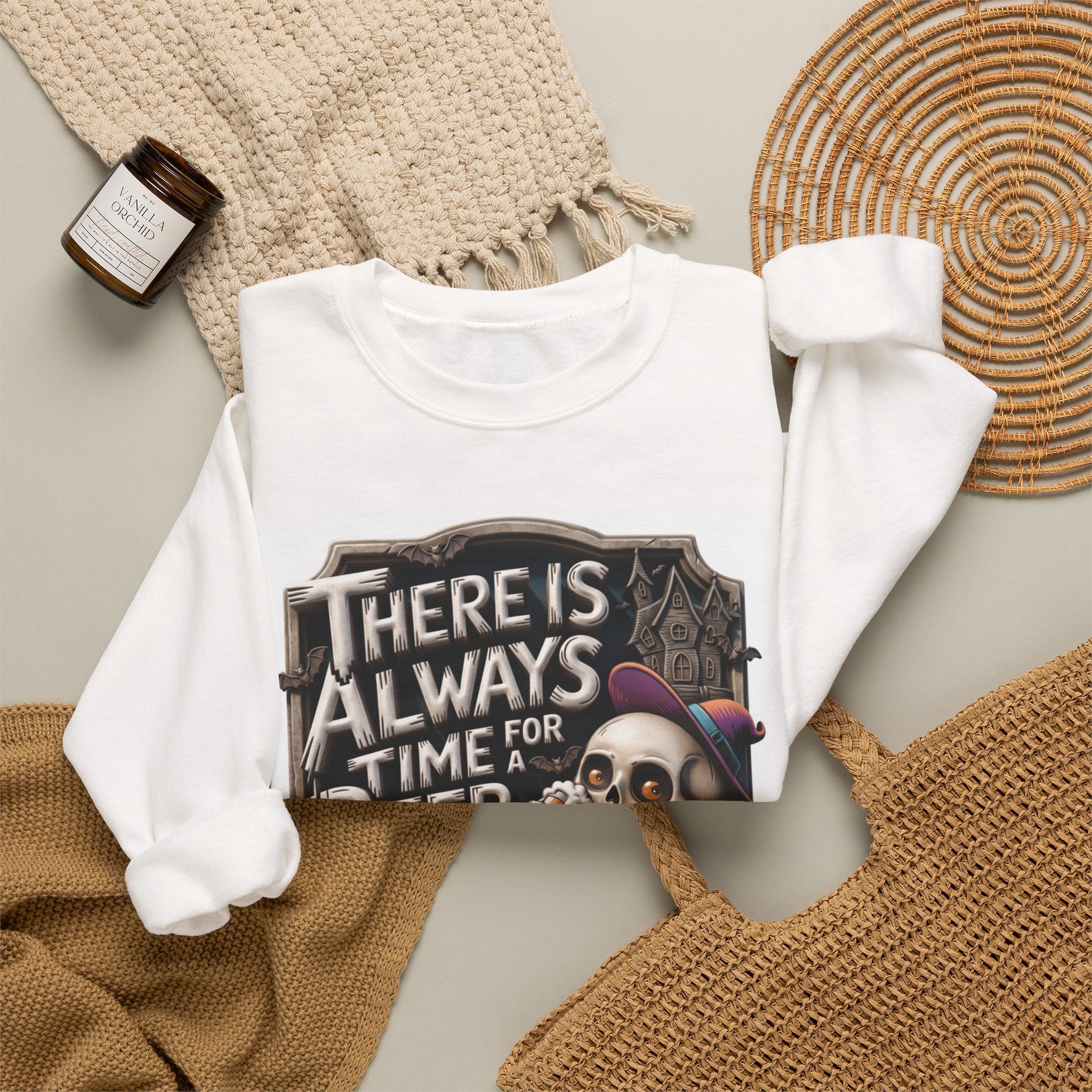 White crewneck sweatshirt styled flat with a candle — skeleton in a floppy purple hat