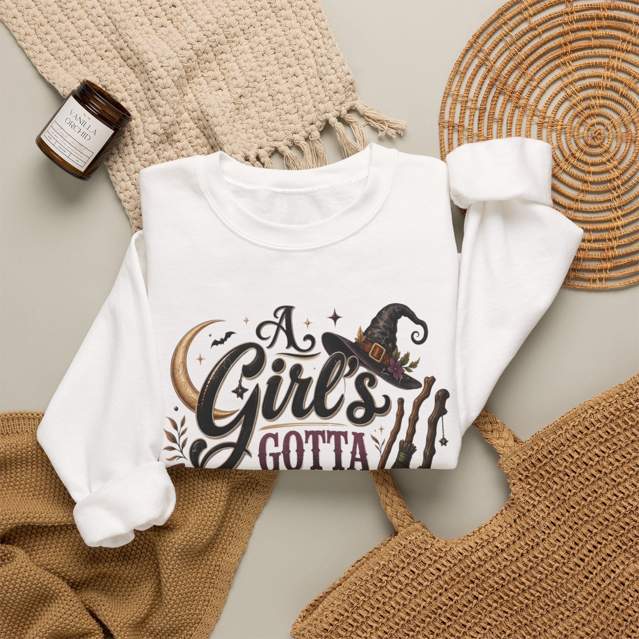 White crewneck sweatshirt styled flat with a candle — hand-lettered A Girl's Gotta Have Options