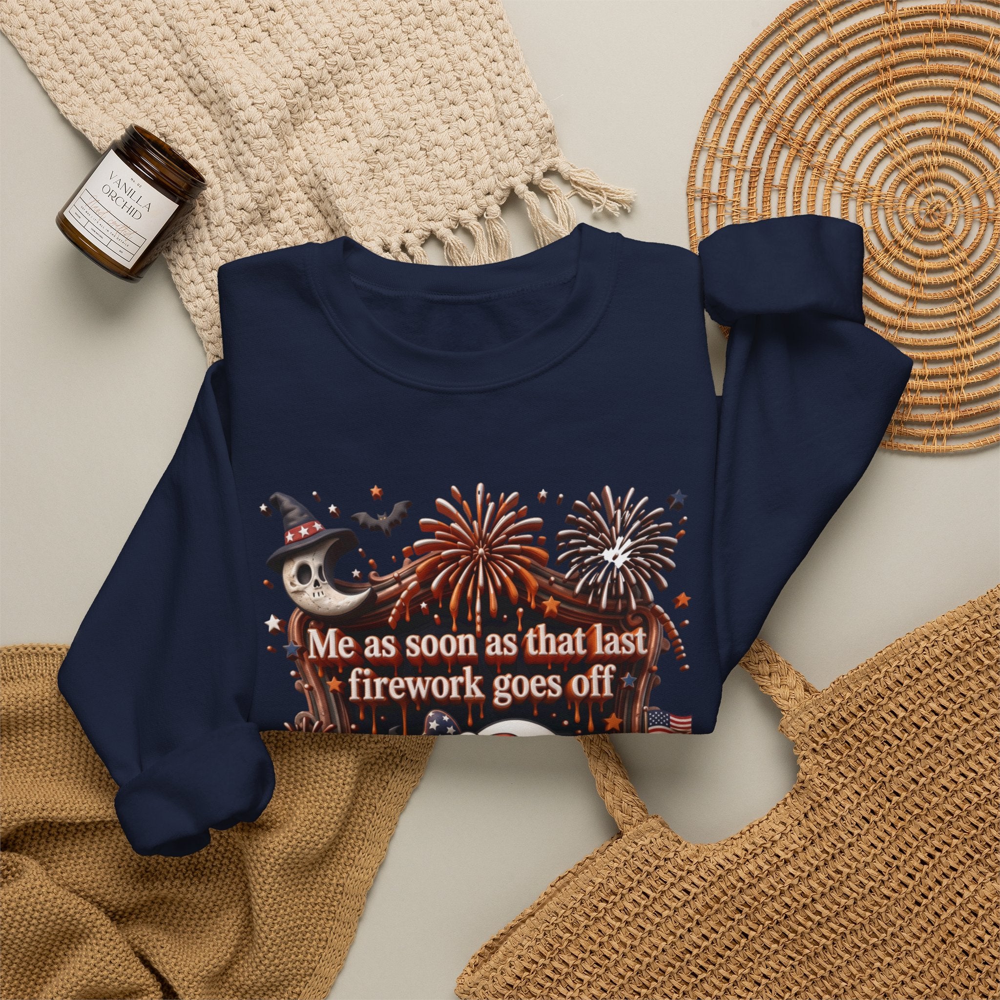 Navy crewneck sweatshirt styled flat with a candle — wide-eyed ghost clutching a firework