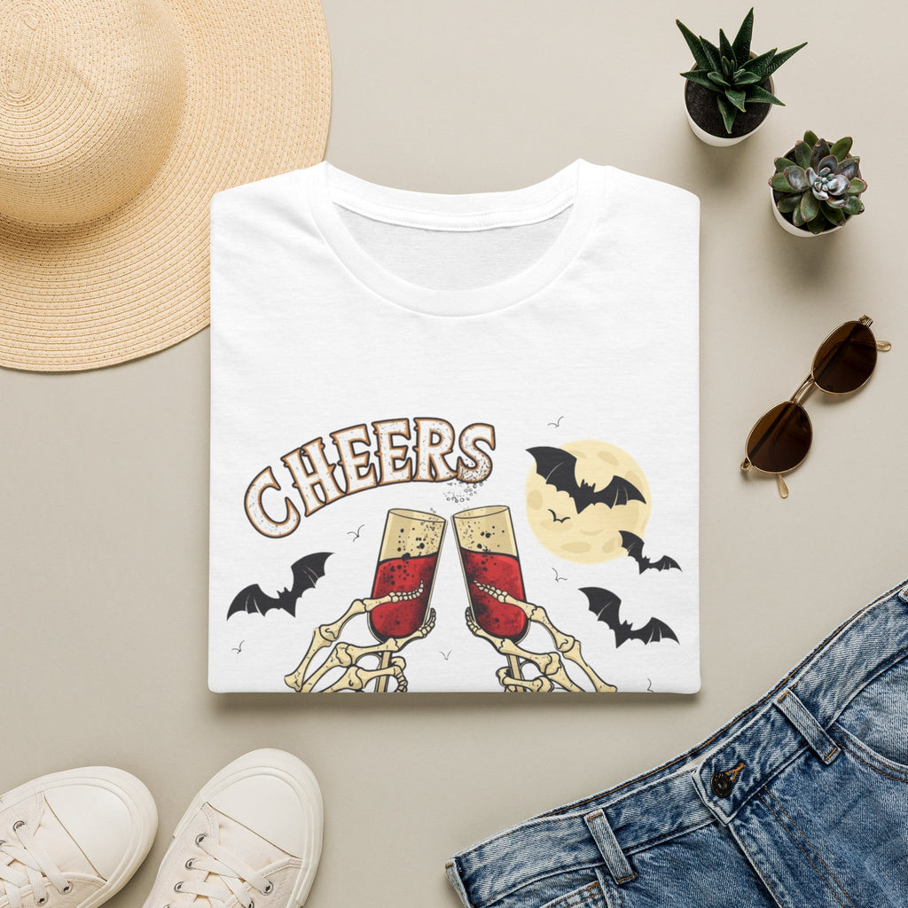 White t-shirt styled flat with a candle — skeleton hands toasting champagne
