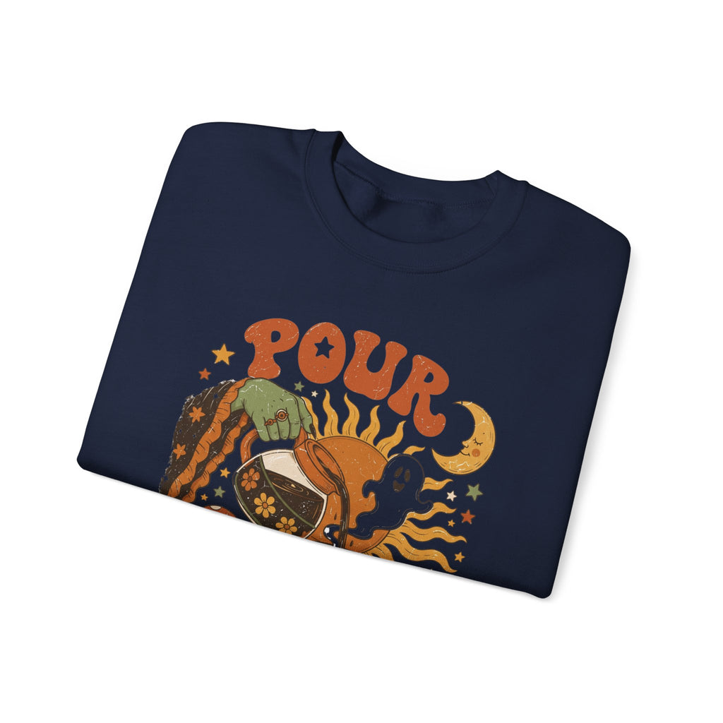 Navy crewneck sweatshirt folded to show the green witch hand tipping a flower-patterned coffee pot into print