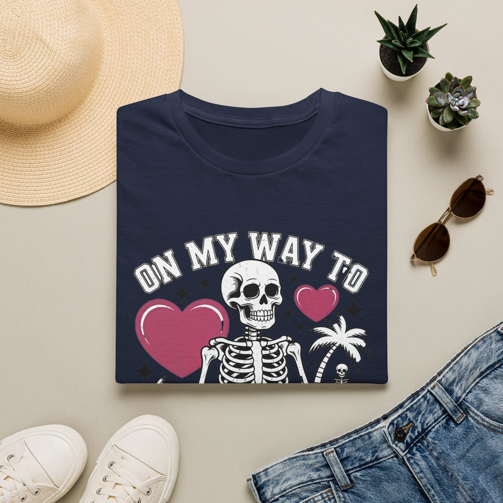 Navy t-shirt styled flat with a candle — line-drawn skeletons under pink hearts