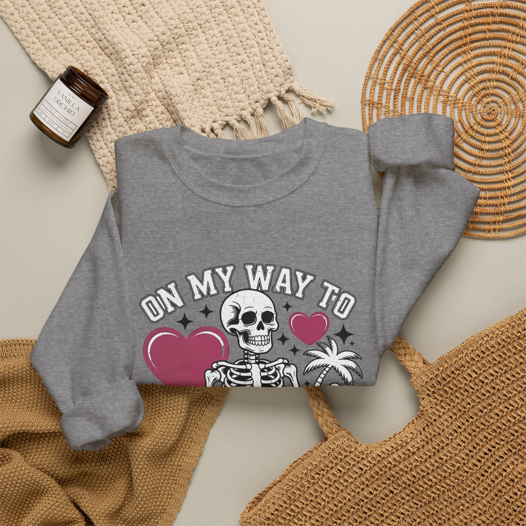 Graphite Heather crewneck sweatshirt styled flat with a candle — line-drawn skeletons under pink hearts