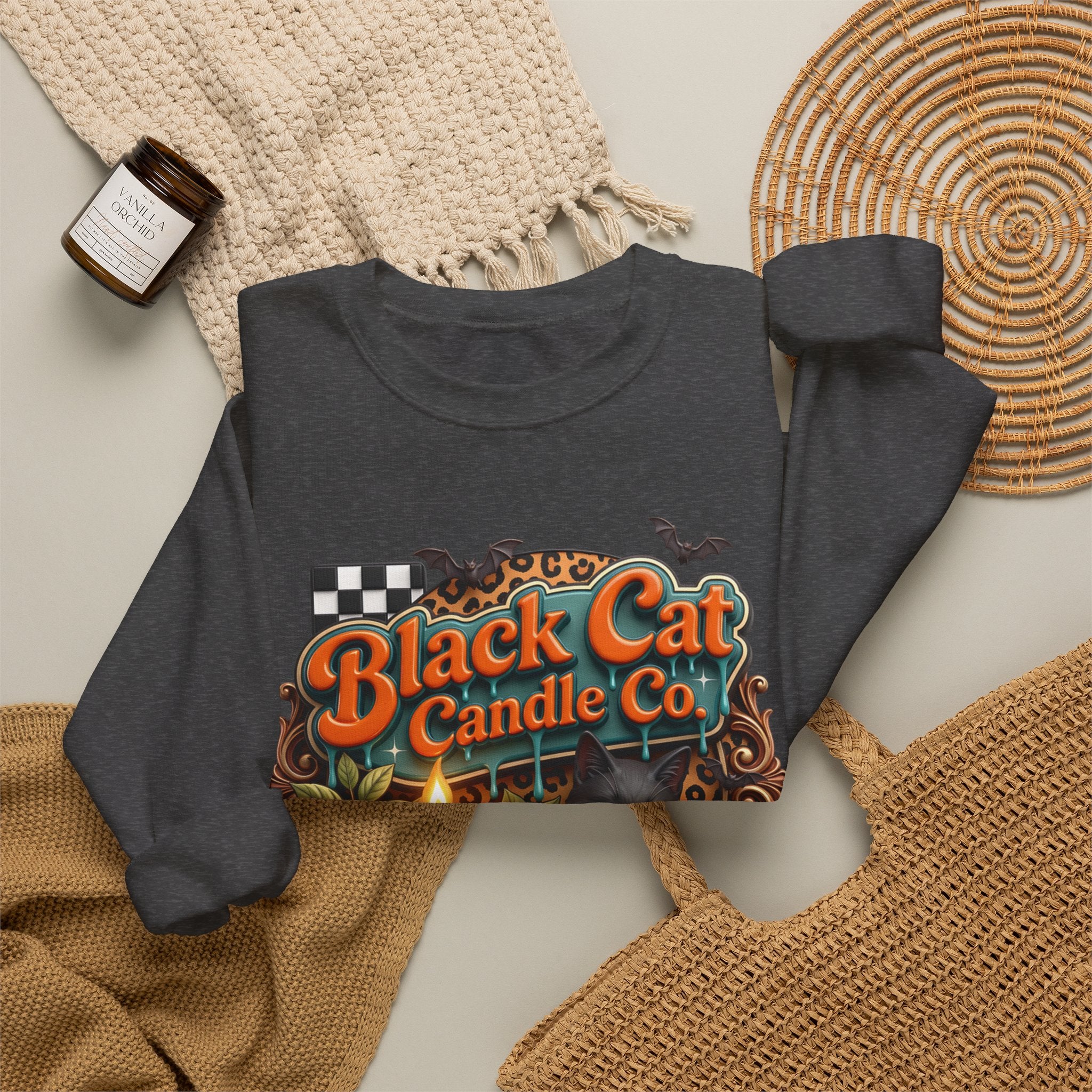 Dark Heather crewneck sweatshirt styled flat with a candle — retro Black Cat Candle Co signboard