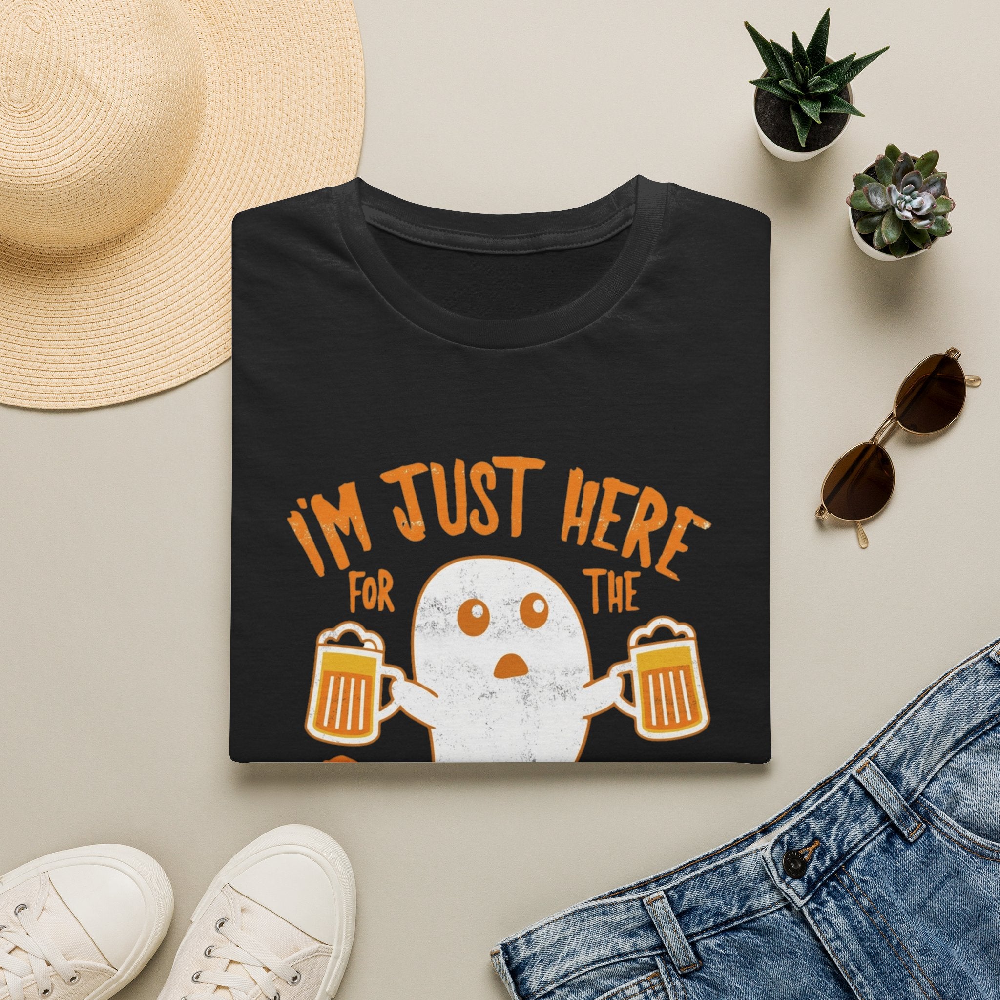 Black t-shirt styled flat with a candle — wide-eyed ghost raising a frothy pint