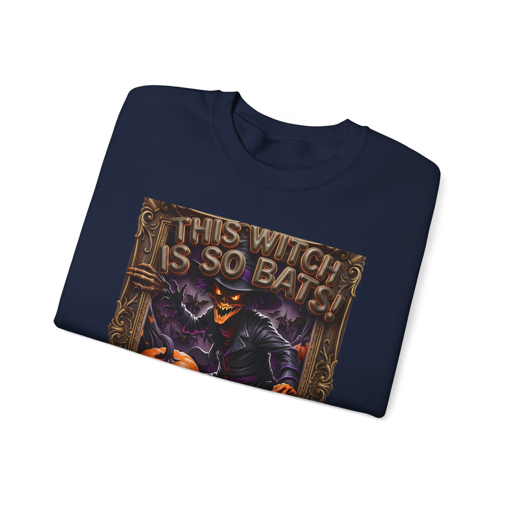 Navy crewneck sweatshirt folded to show the grinning witch in a pointed hat looms over glowing print