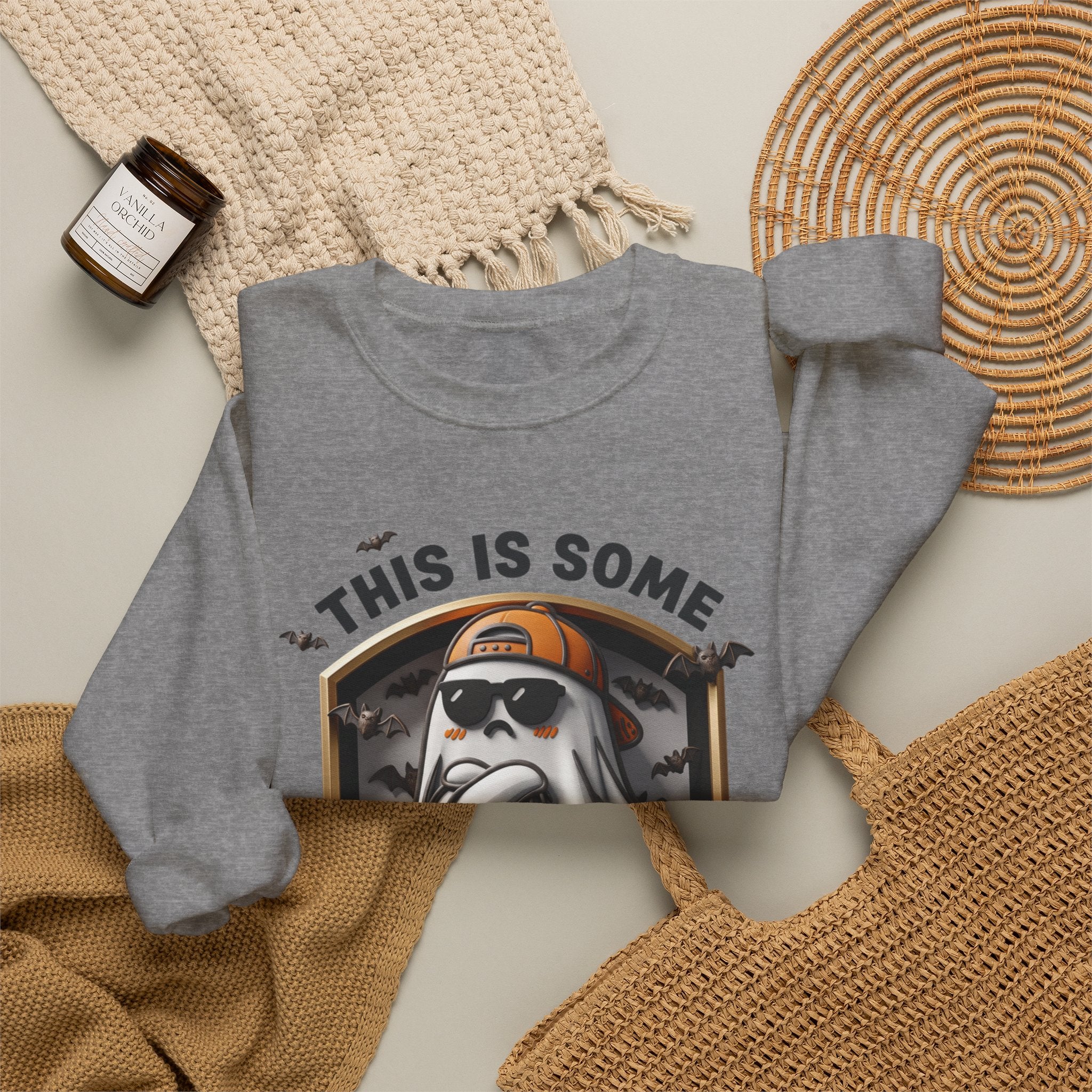 Graphite Heather crewneck sweatshirt styled flat with a candle — sheet ghost in an orange cap